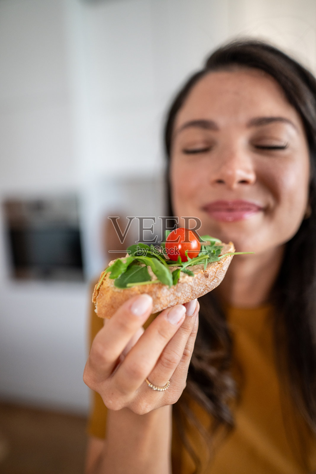 一位女士闭着眼睛享用新鲜健康的沙拉三明治照片摄影图片