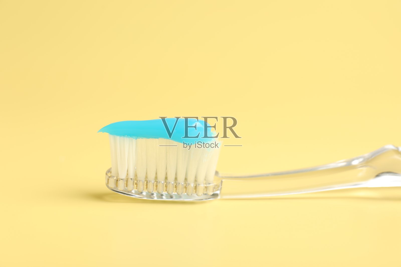特写：牙刷上沾有牙膏，背景为黄色照片摄影图片