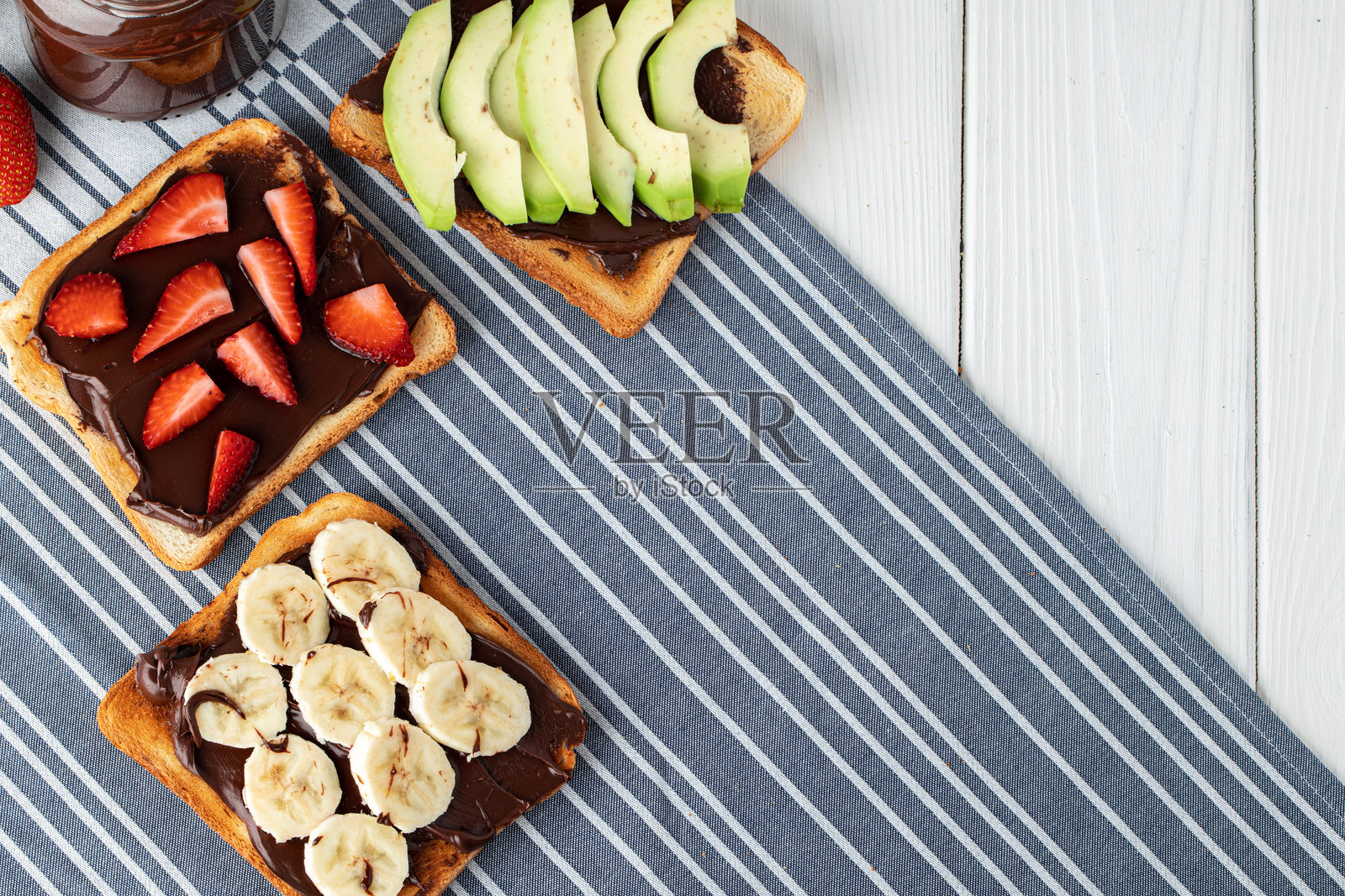 各种甜味三明治，配有巧克力酱、花生酱和水果片照片摄影图片