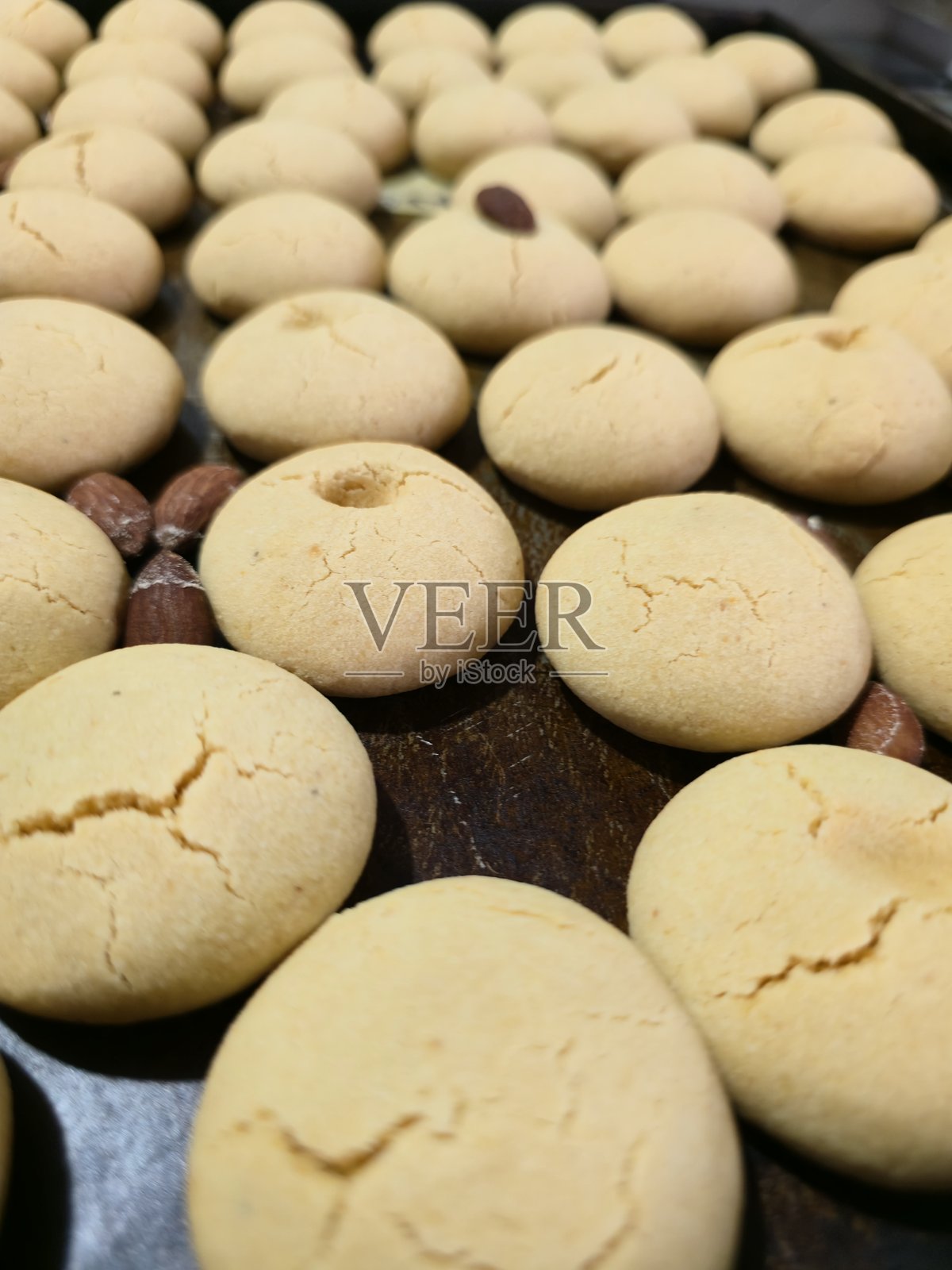 烤箱烤盘上摆放着新鲜出炉的、撒有杏仁的印度酥饼照片摄影图片