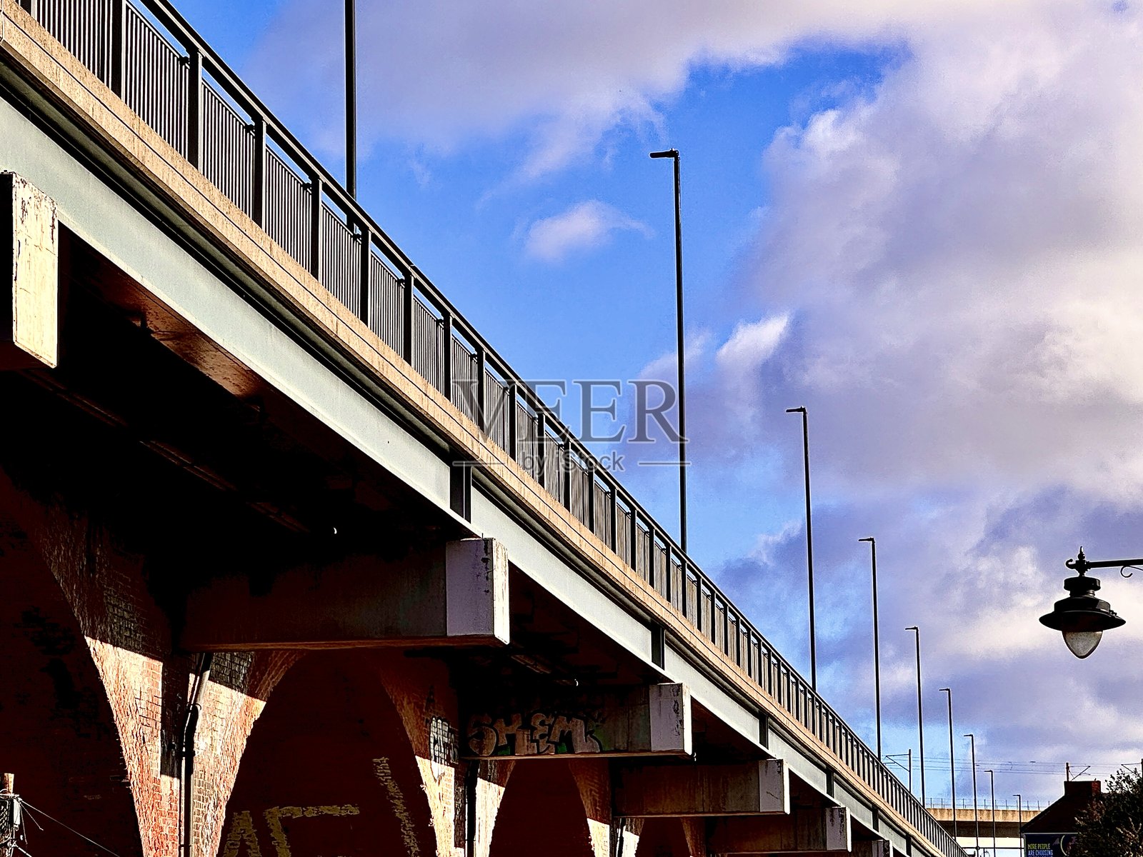 纽卡斯尔联泰克拜克桥侧面视角，一排路灯映衬着云景照片摄影图片