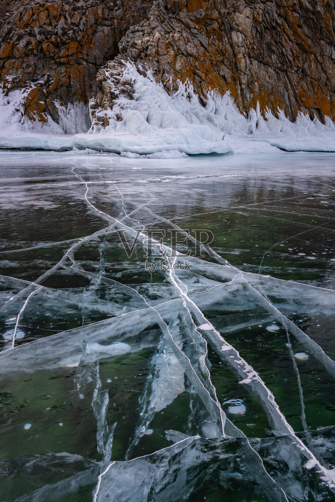 西伯利亚贝加尔湖冬季结冰的悬崖和开裂的黑冰，垂直的冬日风光照片摄影图片