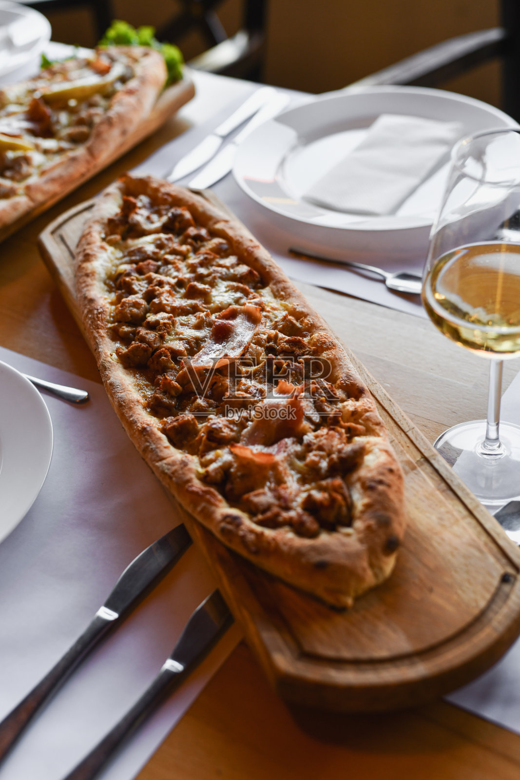 木板上的帕斯特马利娅馅饼，配有酒杯和优雅的餐桌布置照片摄影图片