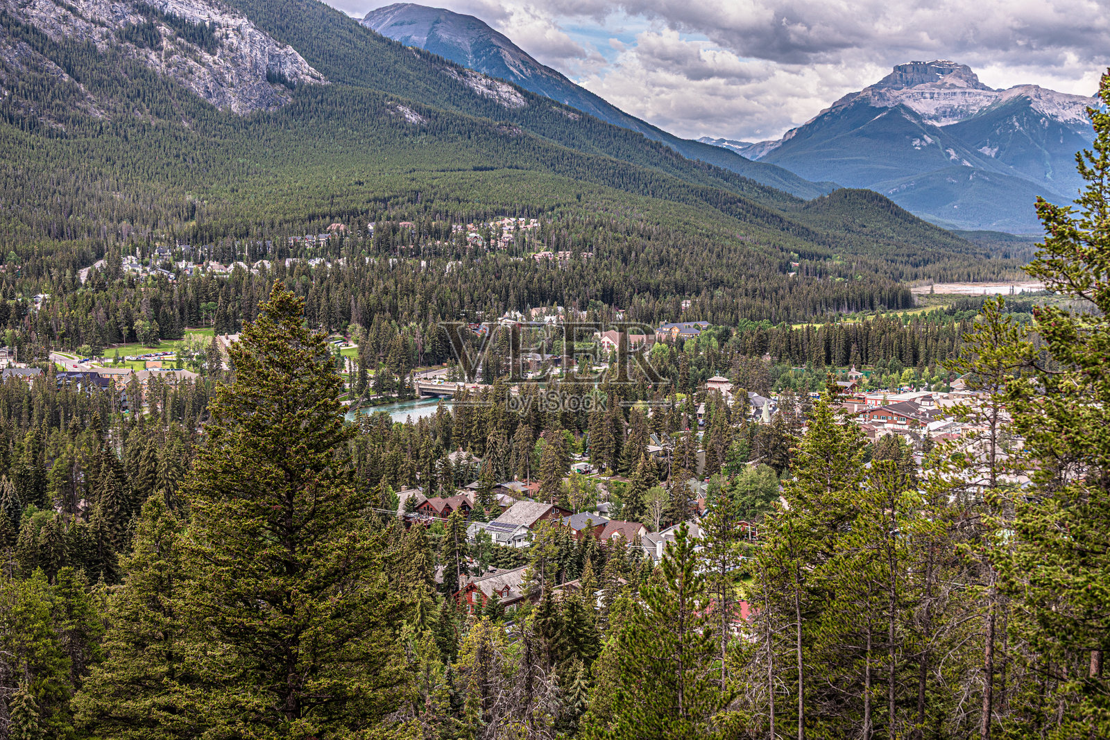 班夫镇坐落于弓谷，四周环绕着群山。照片摄影图片