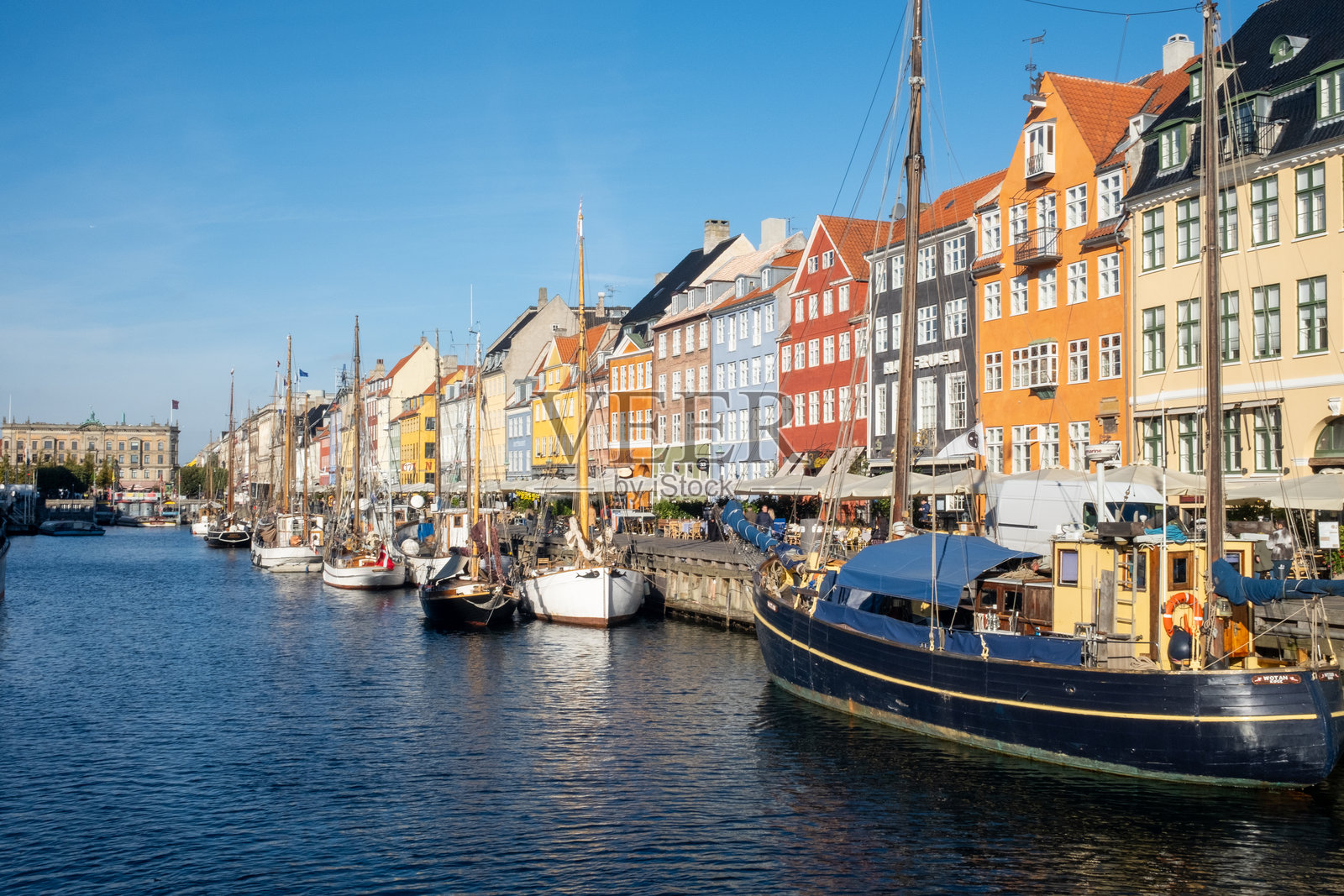 哥本哈根尼港色彩缤纷的房屋与运河边的船只照片摄影图片