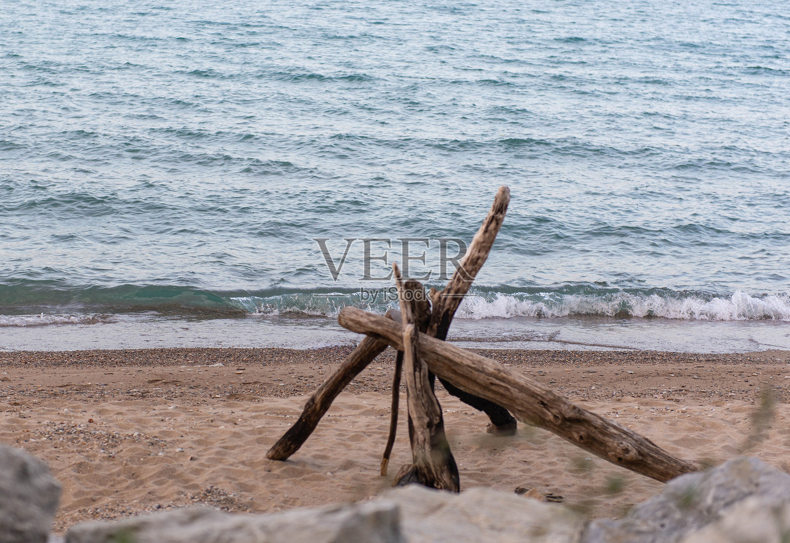 沙滩上的浮木和一小波海浪照片摄影图片