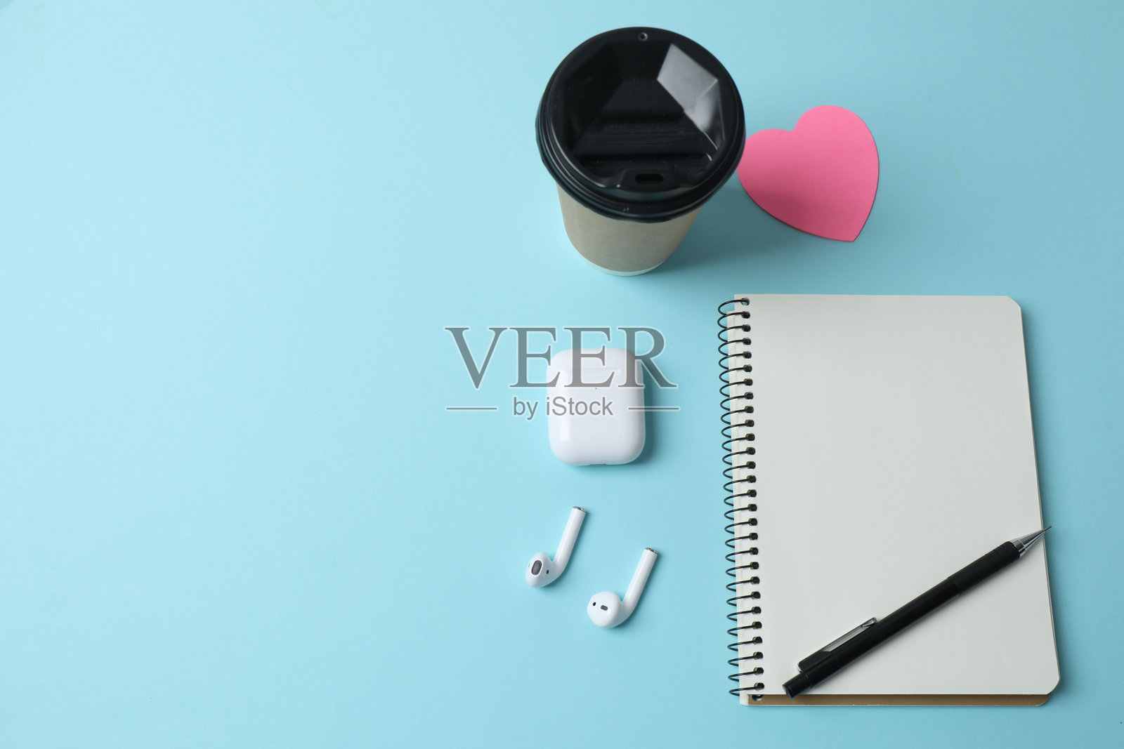 蓝色背景上的笔记本电脑、眼镜、咖啡、耳机和记事本，并留有文本空间照片摄影图片