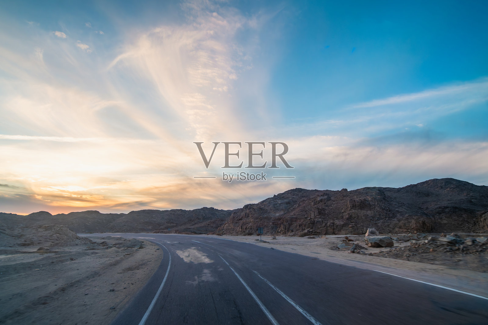 埃及红海赫尔格达附近的沙漠公路日落景观。照片摄影图片