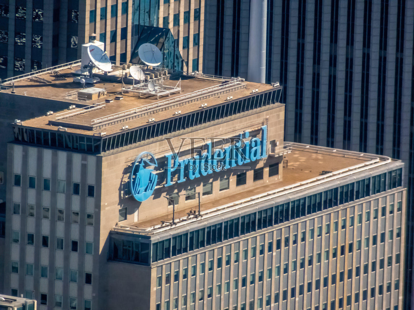 保诚集团的标志高高矗立在摩天大楼顶端，象征着企业金融、稳定性和强大的城市影响力。照片摄影图片