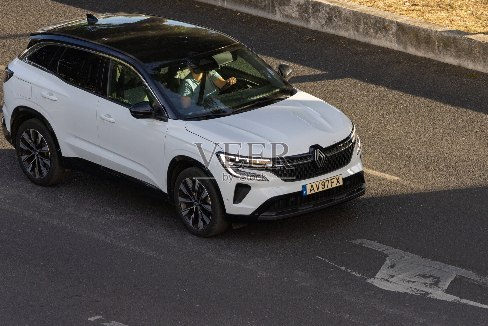 白色的雷诺Austral SUV在沥青路上行驶照片摄影图片