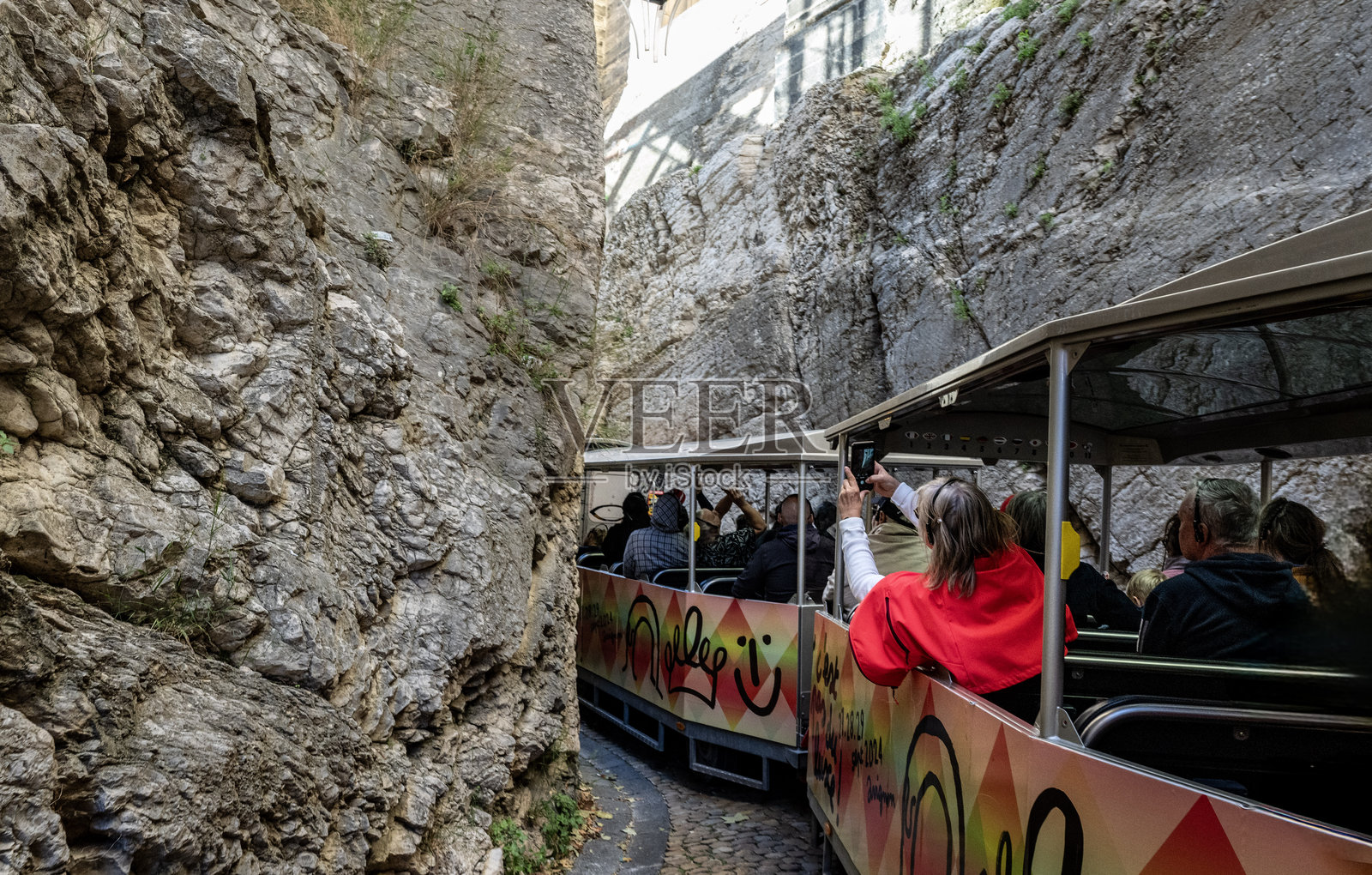 游客乘坐玩具小火车穿过法国普罗旺斯阿维尼翁的狭窄街道照片摄影图片