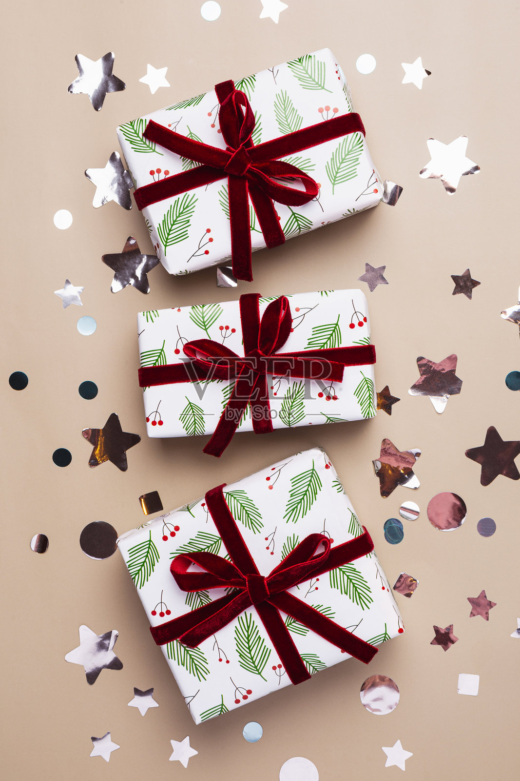 新年垂直贺卡，米色背景上有圣诞礼物盒和银色装饰，留有文字复制空间照片摄影图片