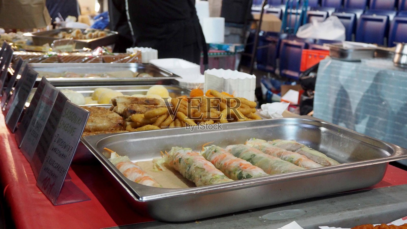 波兰什切青 - 2025 年 10 月 19 日：自助餐托盘上摆放着新鲜的鲜虾饭卷和酥脆的炸圈，非常适合美食摄影或海鲜餐厅推广。照片摄影图片