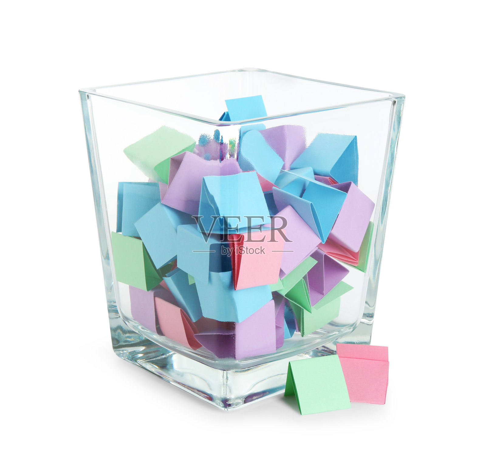 许多彩色的纸片在玻璃杯中，孤立在白色背景上照片摄影图片