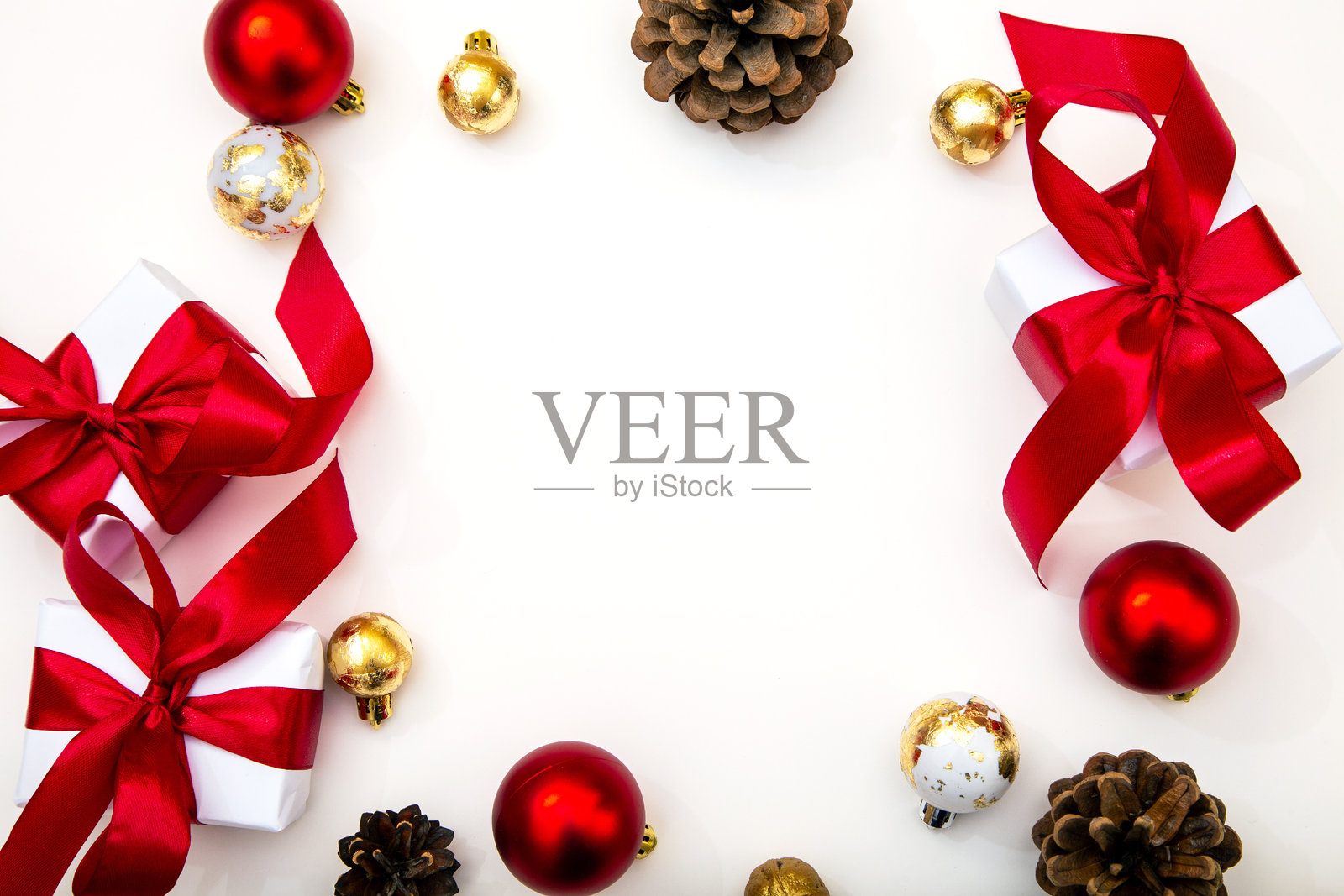 白色礼品盒，配有红色丝带、松果和圣诞球，背景为白色，留有复制空间。节日俯视拍摄，适合圣诞节和新年。照片摄影图片