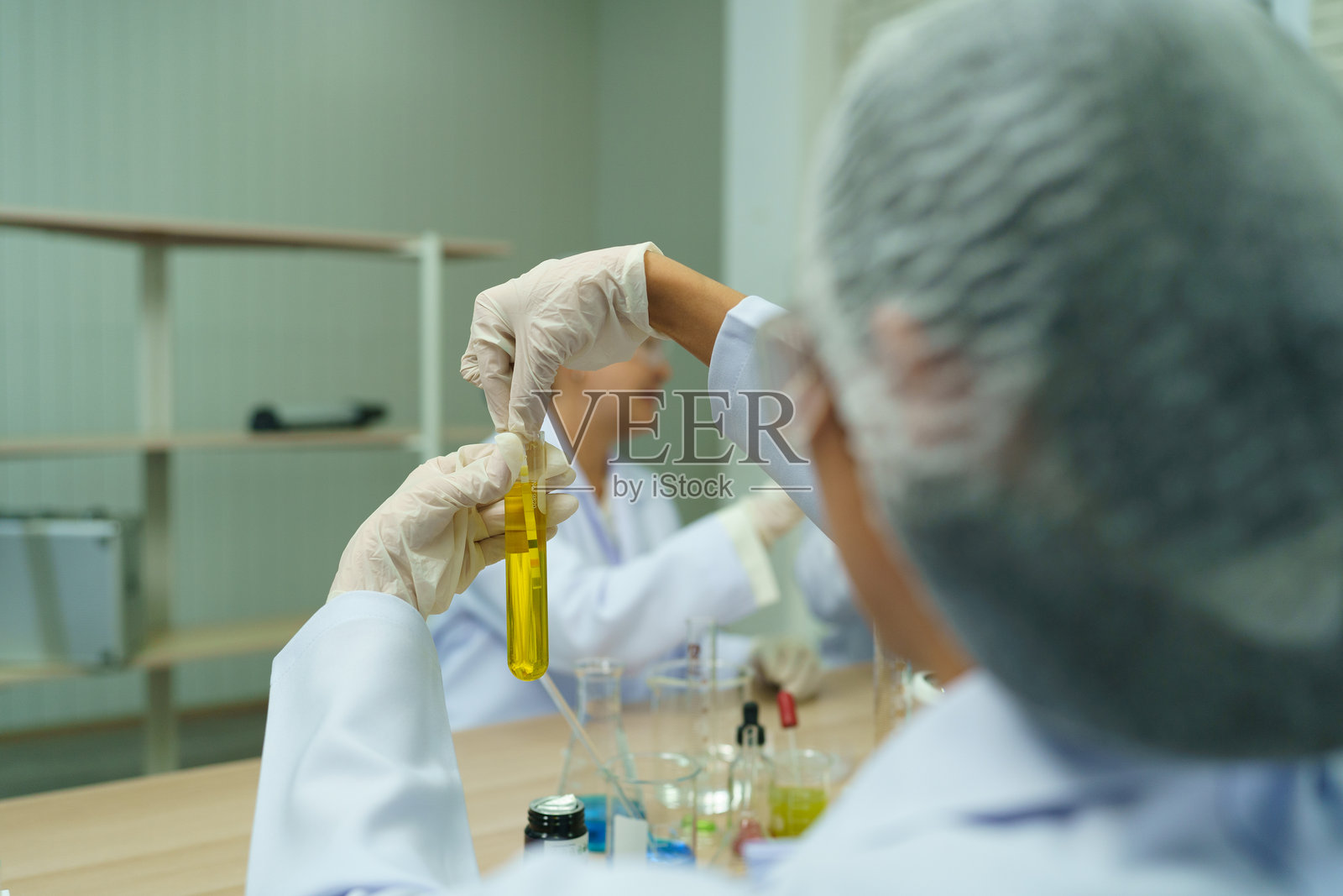 一群科学家正在实验室教室里分析分子并用试管进行实验。照片摄影图片