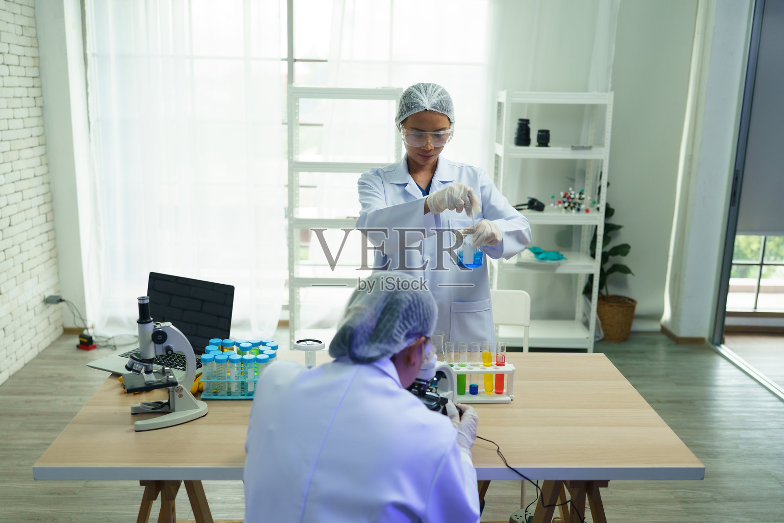 科学家们正在实验室课堂中分析分子并用试管做实验。照片摄影图片