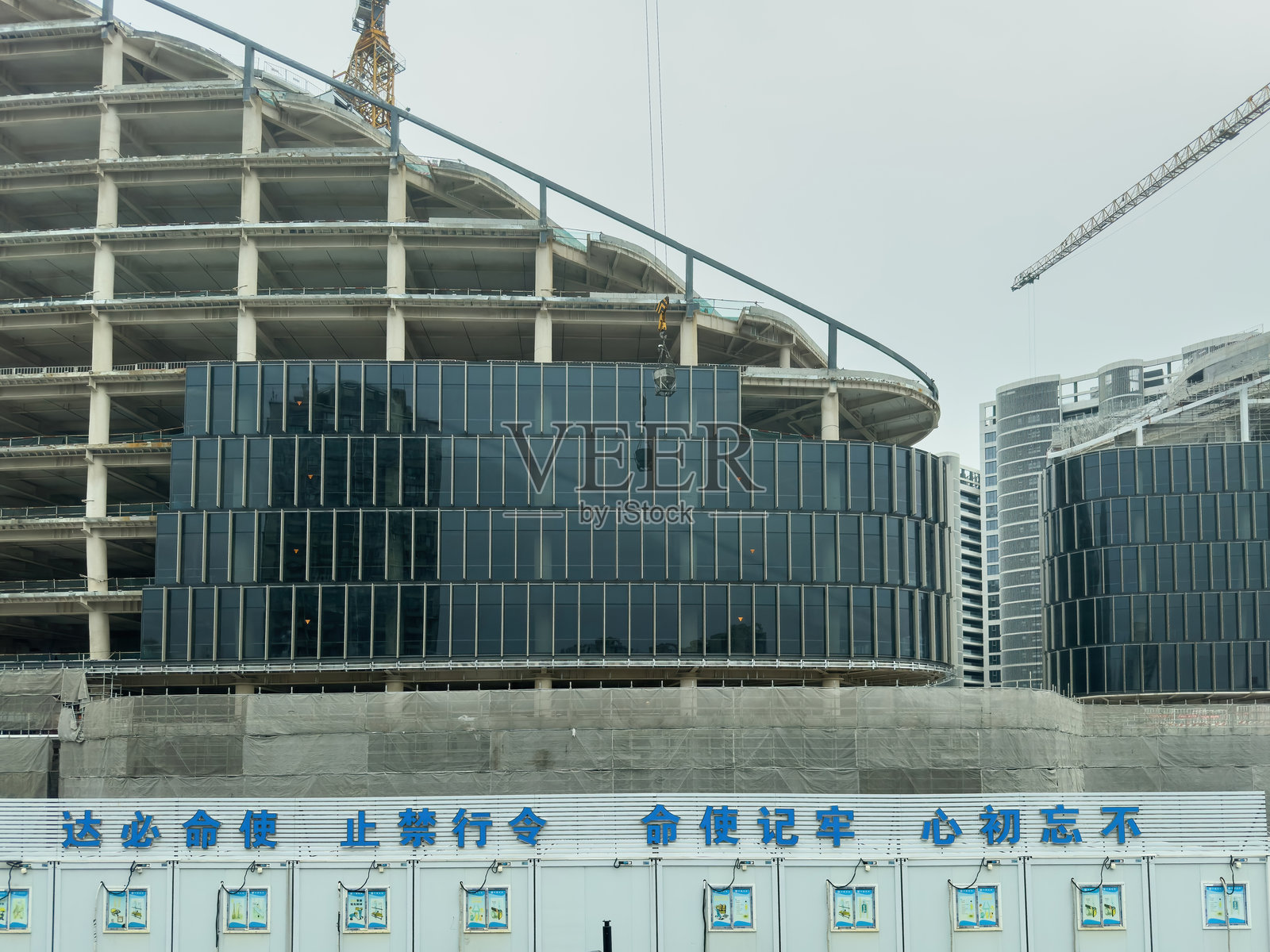 中国上海。正在建设中的现代化办公综合体，拥有玻璃幕墙和起重机，城市发展照片摄影图片