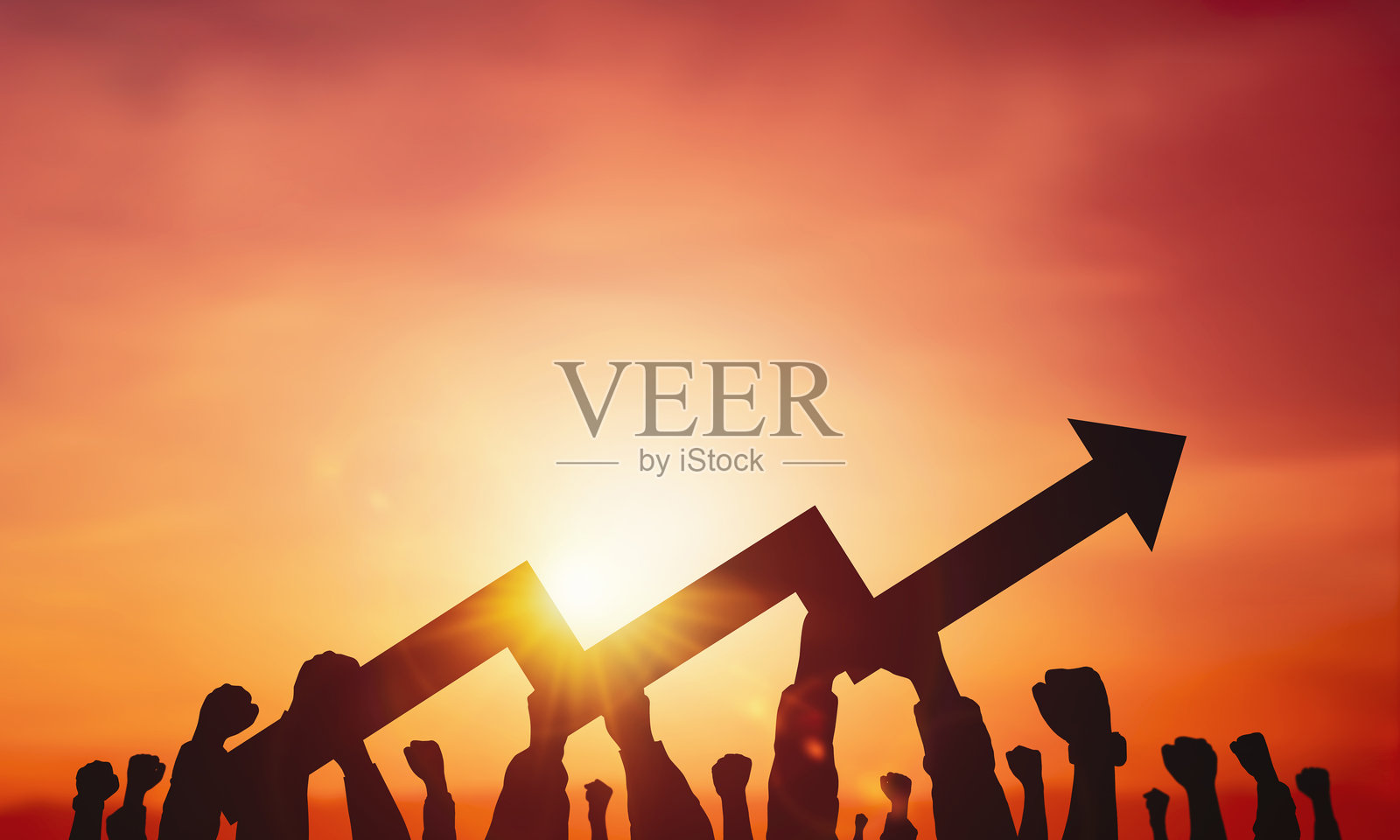 夕阳背景下，许多手举着增长箭头标志的剪影。商业概念，利润增长。照片摄影图片