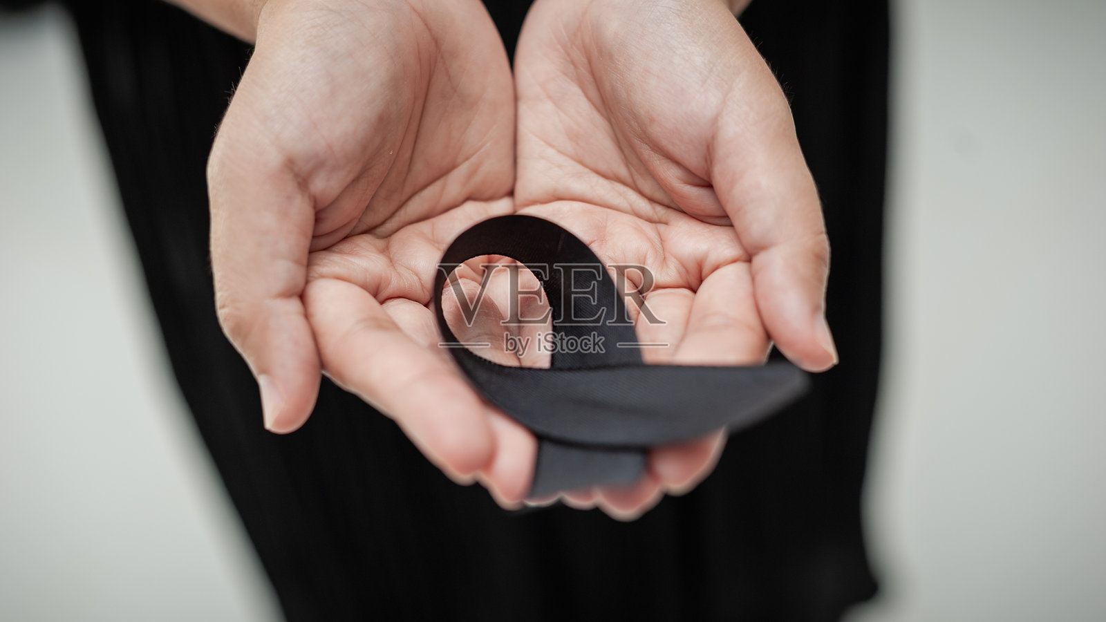 葬礼，带有黑色丝带的纪念仪式，充满情感的氛围，庄严肃穆的场景，手部特写照片摄影图片