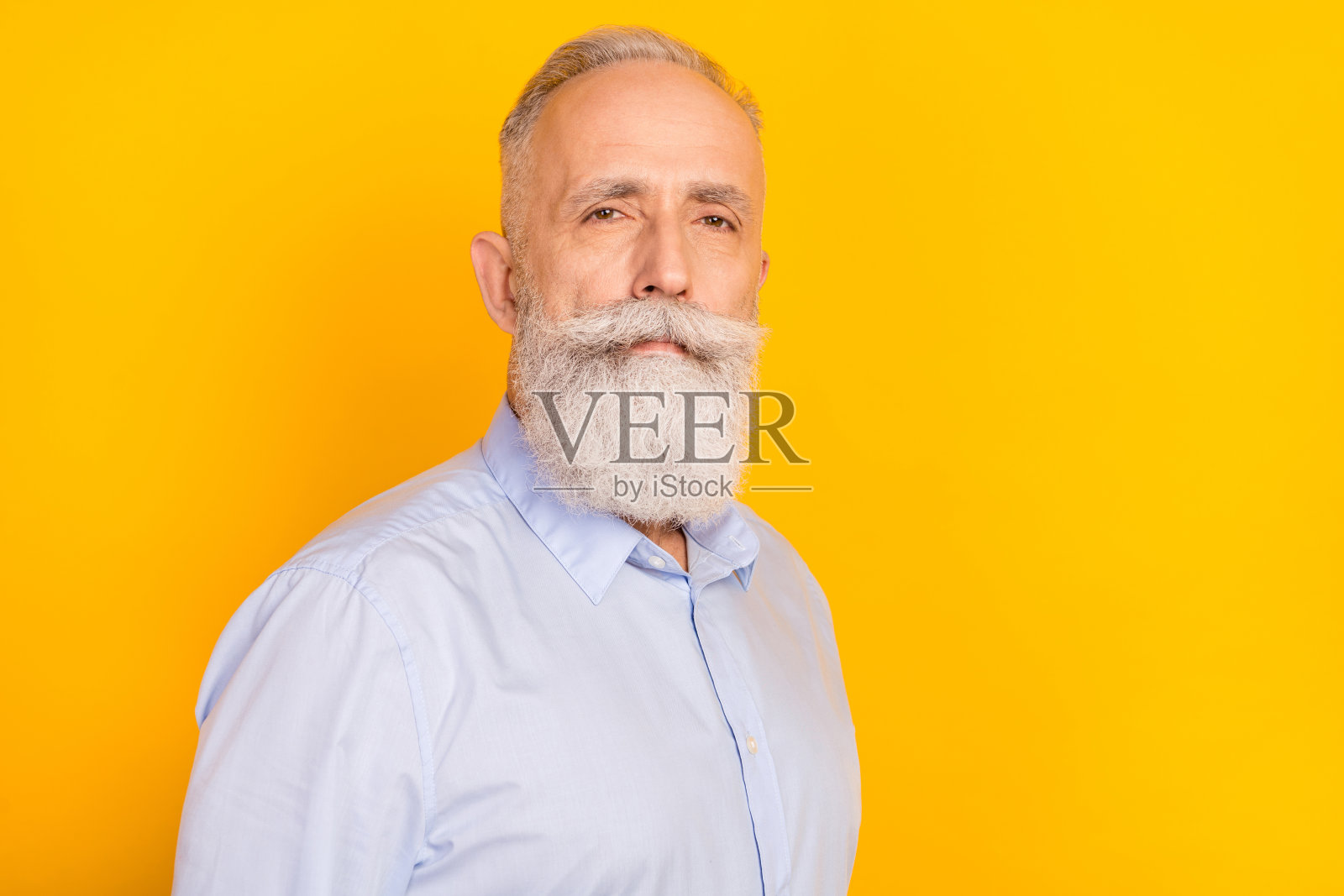 身着正装衬衫、表情严肃、沉着、气度不凡的老爷爷，在黄色背景下拍摄的照片照片摄影图片