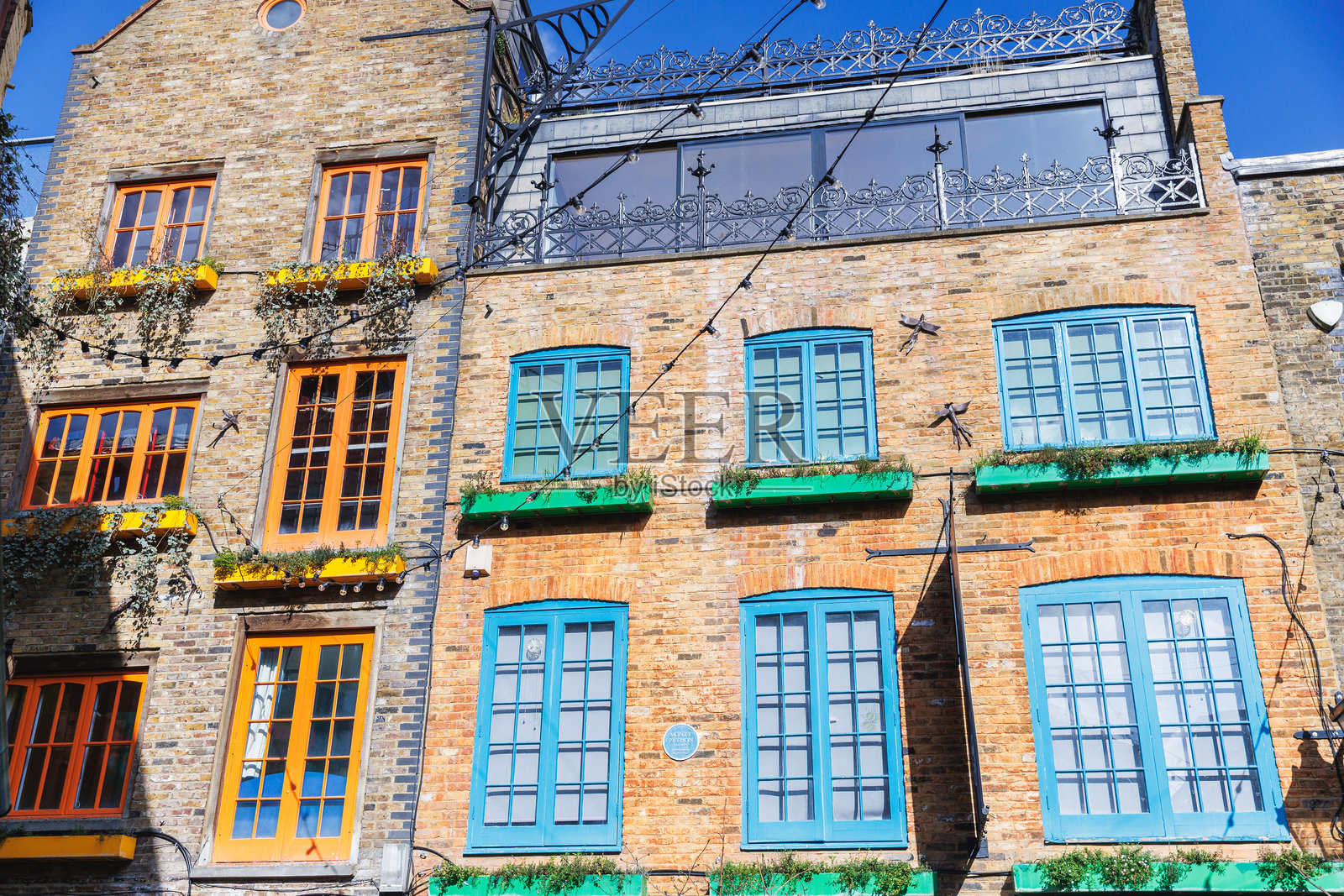 伦敦街景中色彩鲜艳的砖砌建筑，带有亮橙色、蓝色和绿色的窗户照片摄影图片