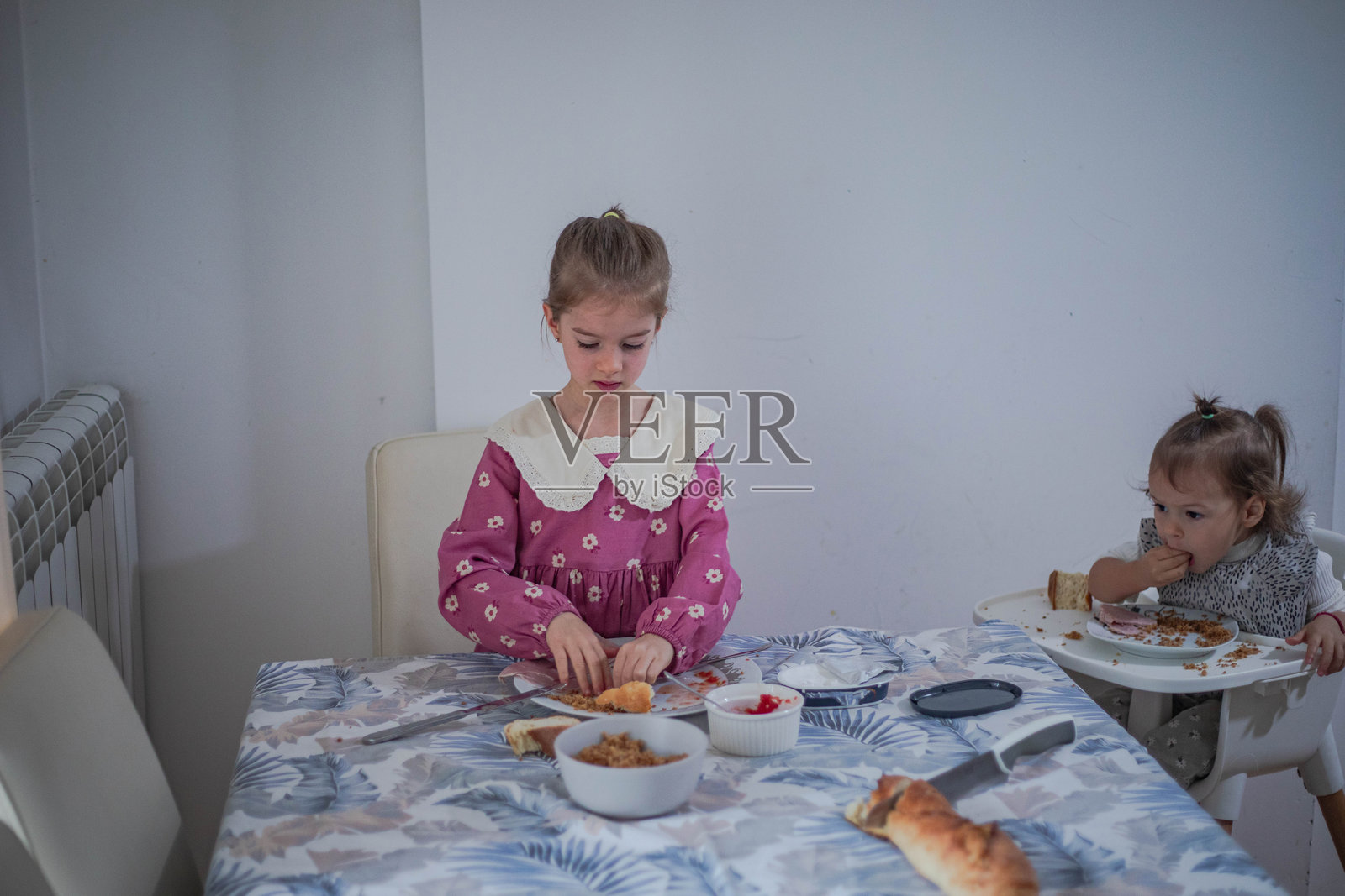 小女孩们在厨房的餐桌旁用餐照片摄影图片