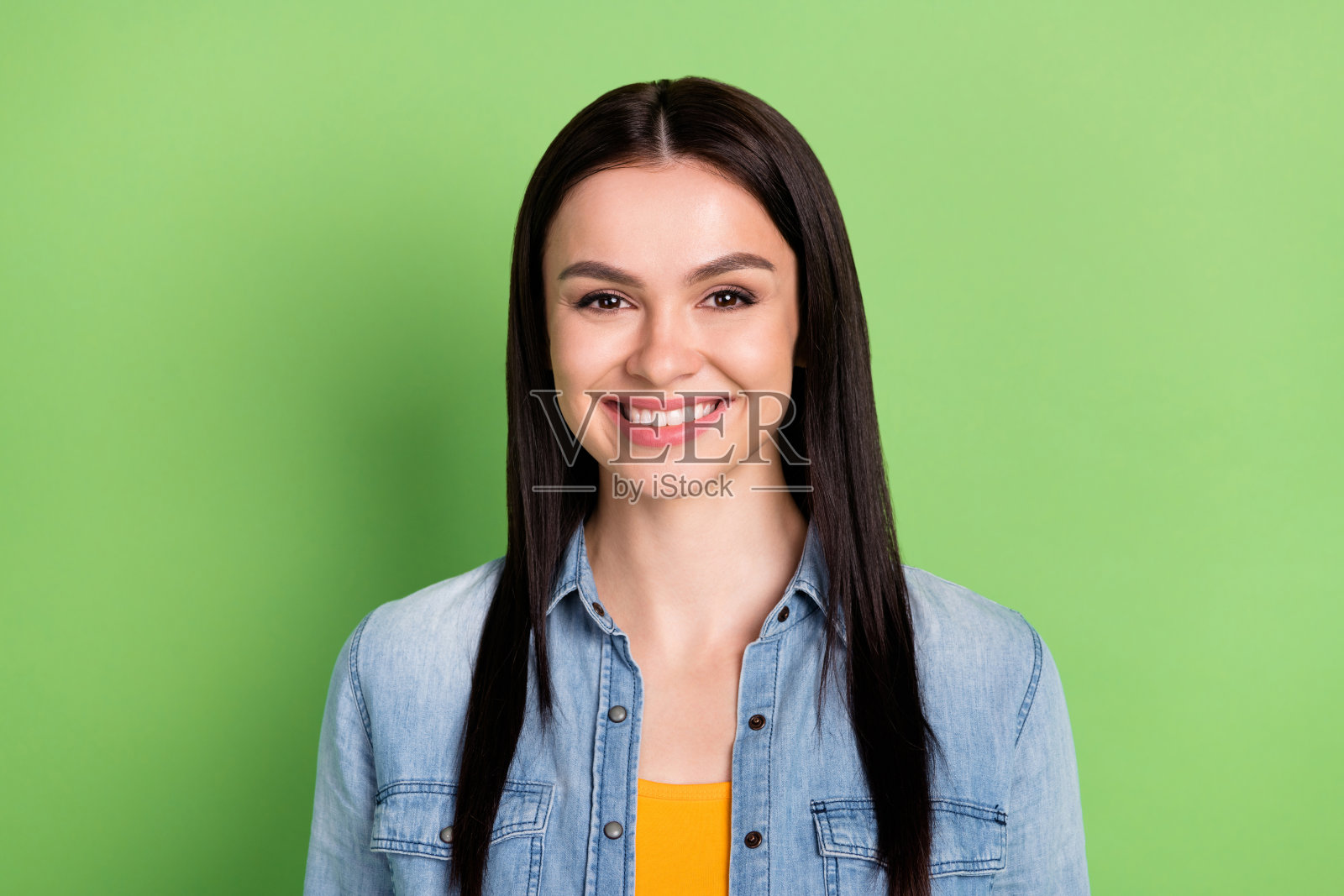 年轻漂亮的快乐女人在接受牙科治疗修复后，在绿色背景上露出笑容照片摄影图片