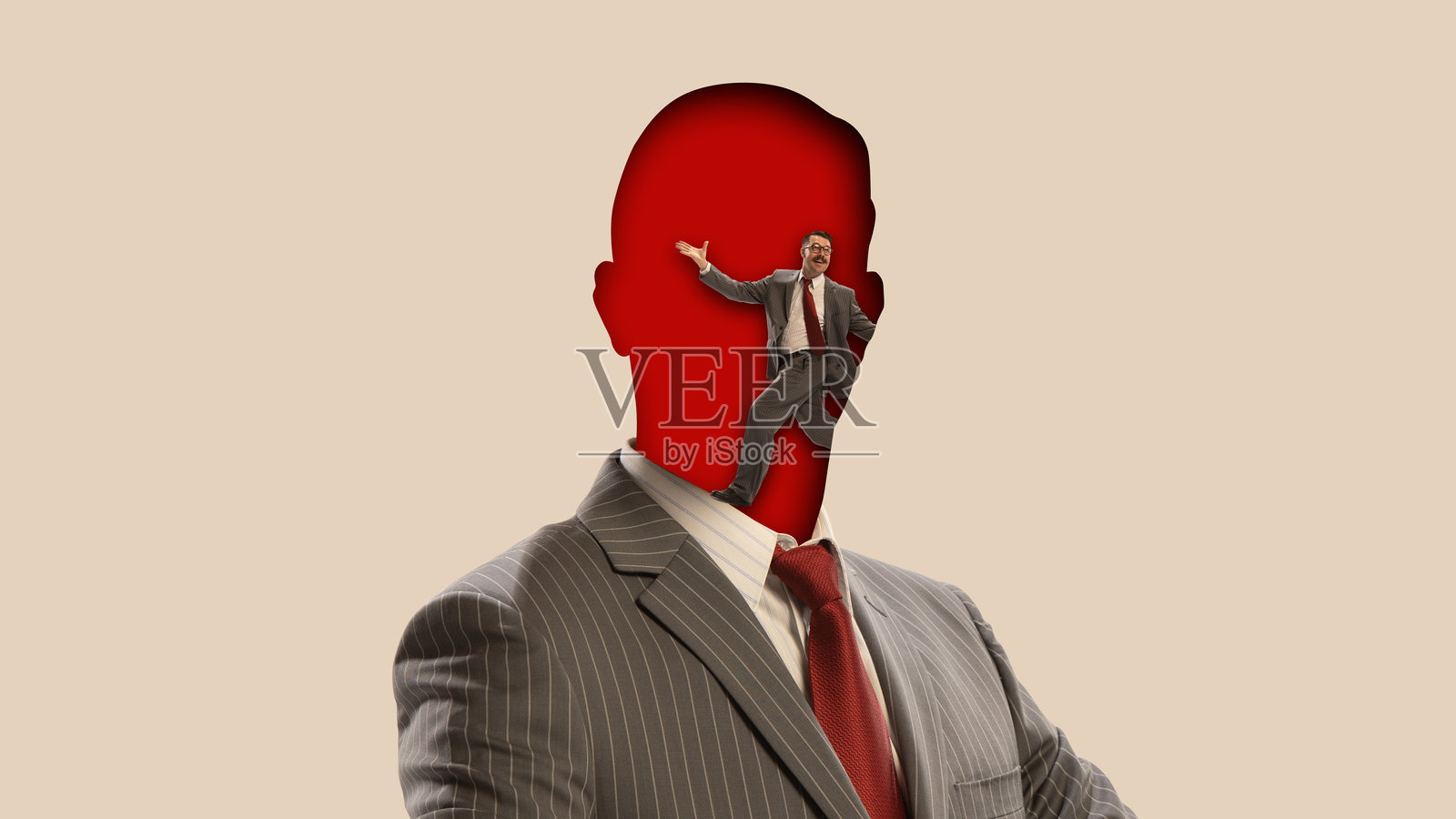 创意拼贴。商人剪影，头脑空间内有较小人物表演照片摄影图片