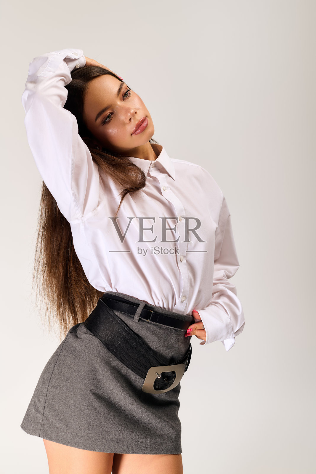 年轻貌美的女子在时尚的灰色影棚中展示秋季时装照片摄影图片