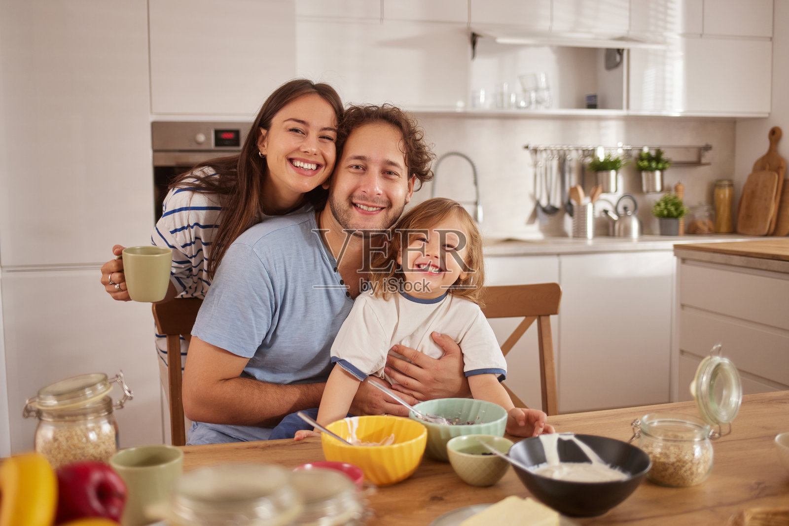 快乐的一家人在厨房享用早餐，孩子也在其中。照片摄影图片