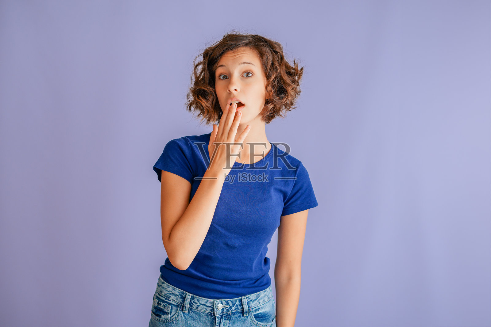 一个好奇心强的年轻学生，表情专注，充满学习的热情，在充满活力的蓝色工作室背景下，散发出好奇的能量。照片摄影图片