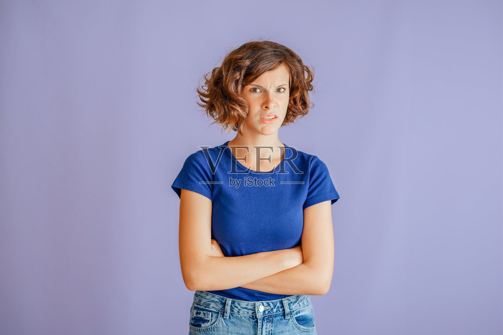 一个忧虑的孩子，面带烦恼的表情，散发出焦虑的氛围，在充满压力的蓝色背景下，表达着他的不赞同，传递出不安的能量，意在表现心理健康概念。照片摄影图片