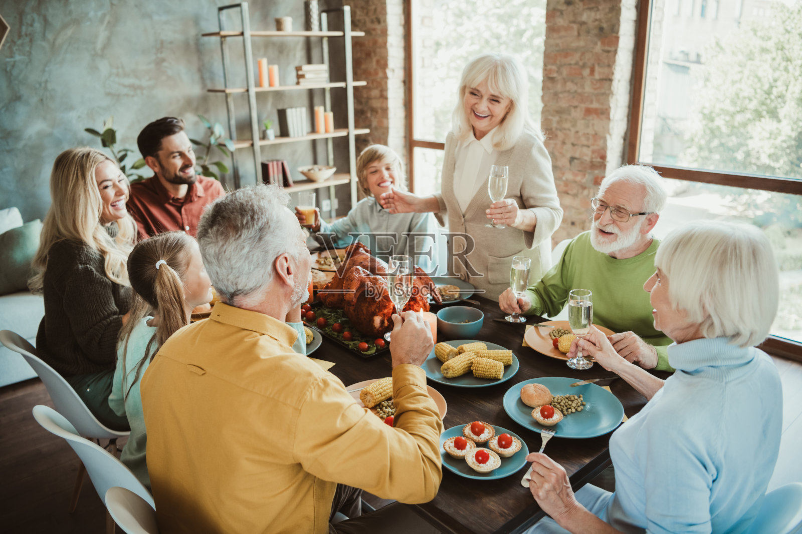 感恩节温馨欢乐的家庭盛宴，一张热闹的餐桌上充满了欢声笑语、爱意与全家亲友共度的美好回忆。照片摄影图片