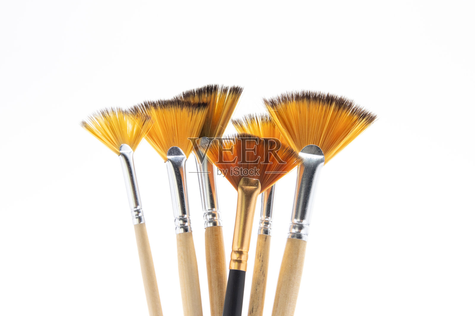 独特的黑色手柄画笔在米色扇形画笔群中脱颖而出，象征着多样性、个性和包容性照片摄影图片