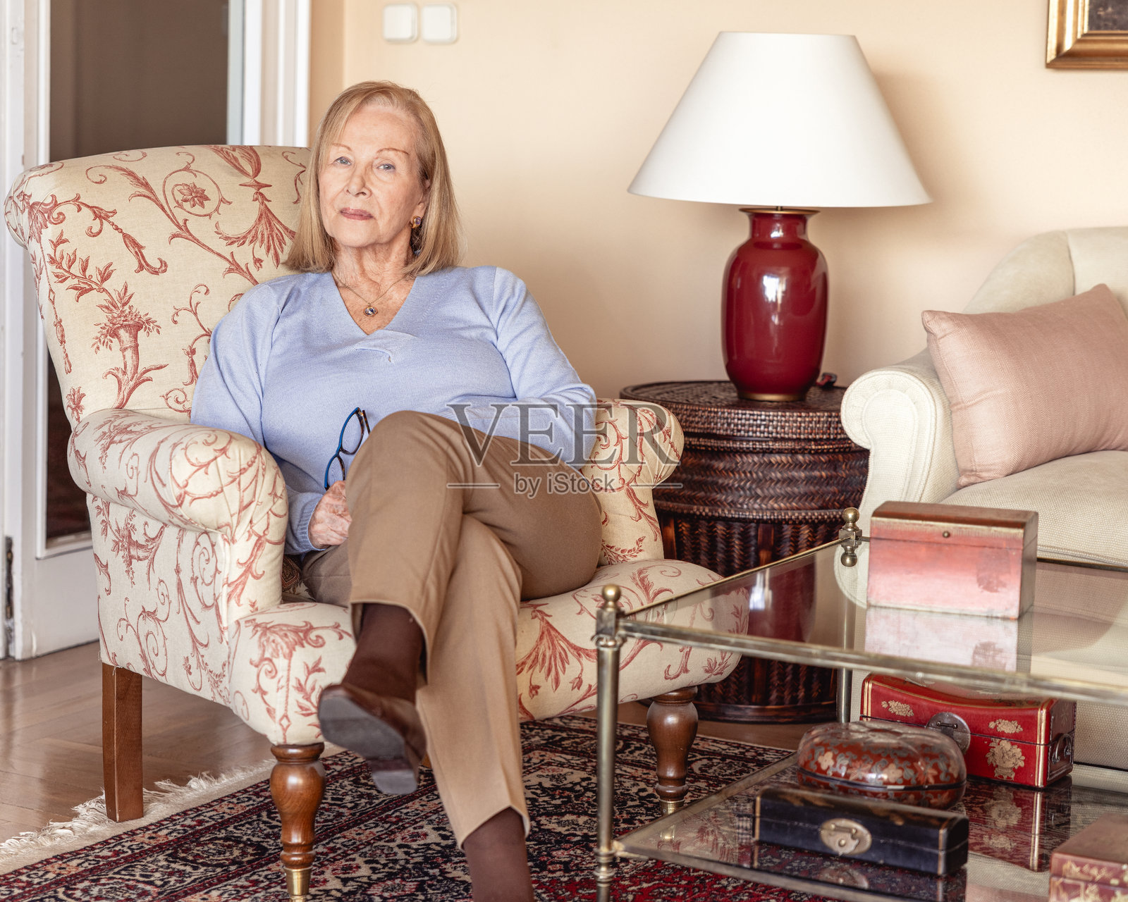 一位时尚的老年女性坐在一间典雅的古典客厅里照片摄影图片