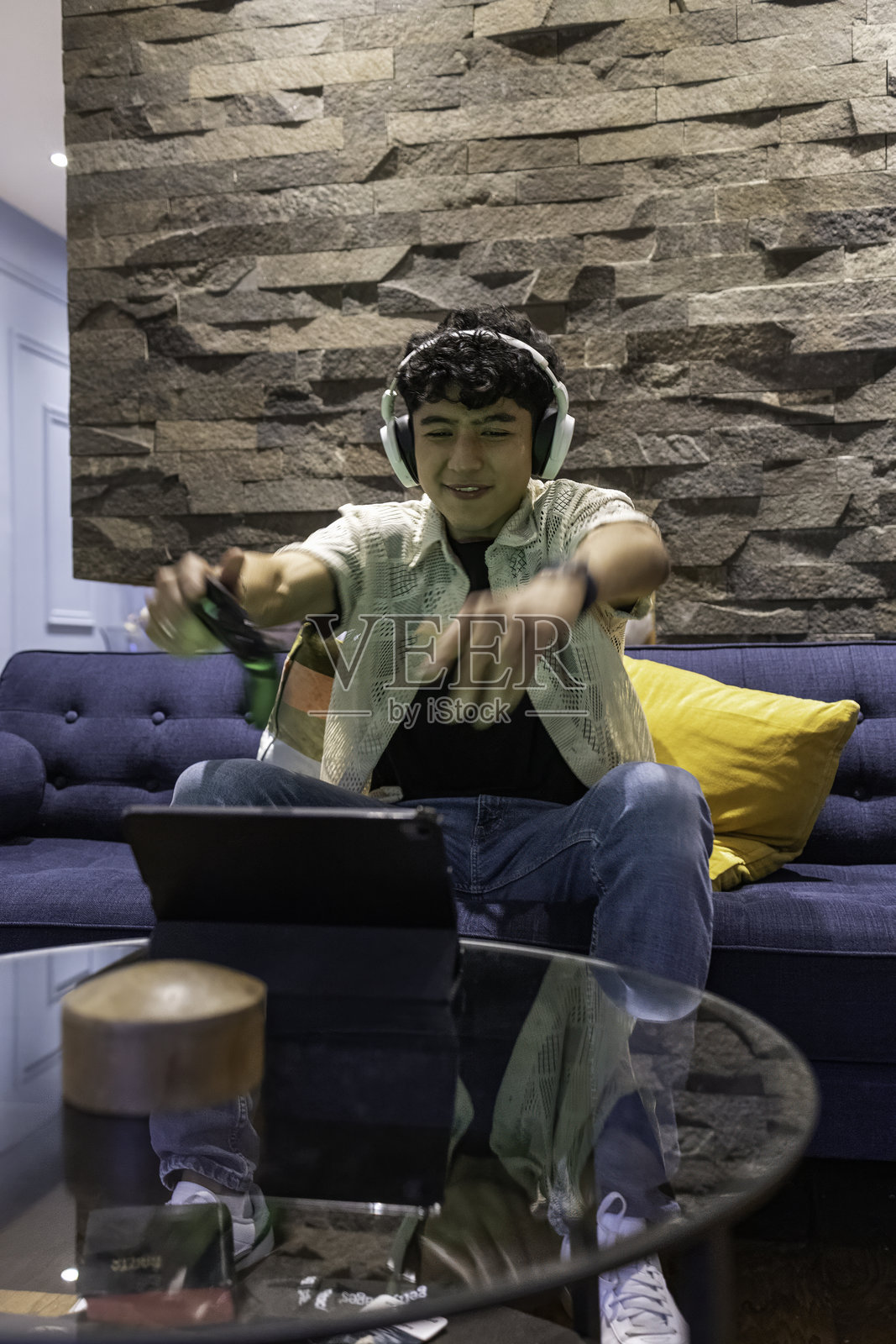 年轻男子在客厅用平板电脑玩电子游戏照片摄影图片