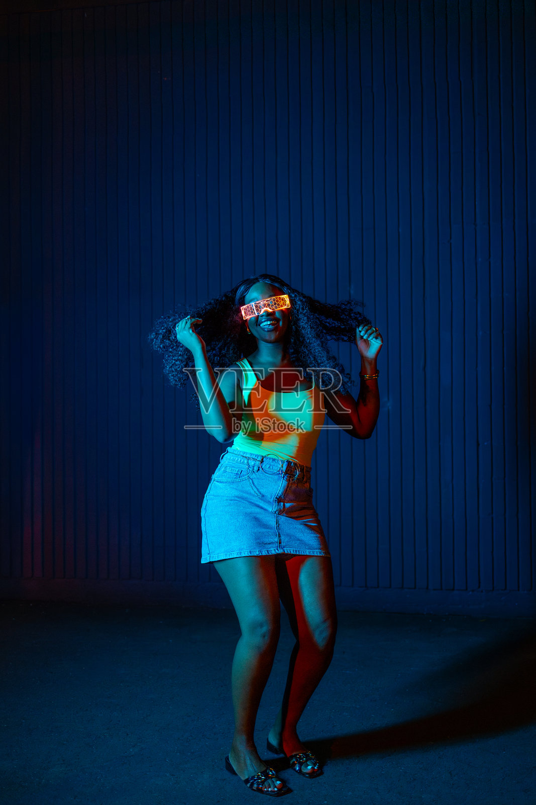 身着未来感眼镜和休闲装的活力四射的黑人女性在跳舞照片摄影图片