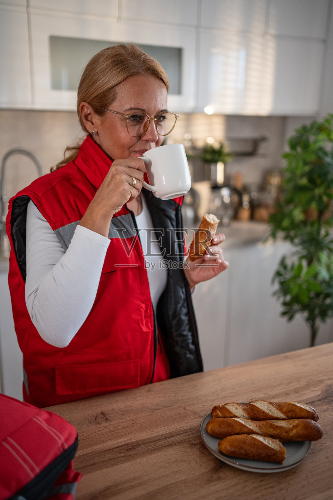女急救员在厨房喝咖啡吃零食休息照片摄影图片