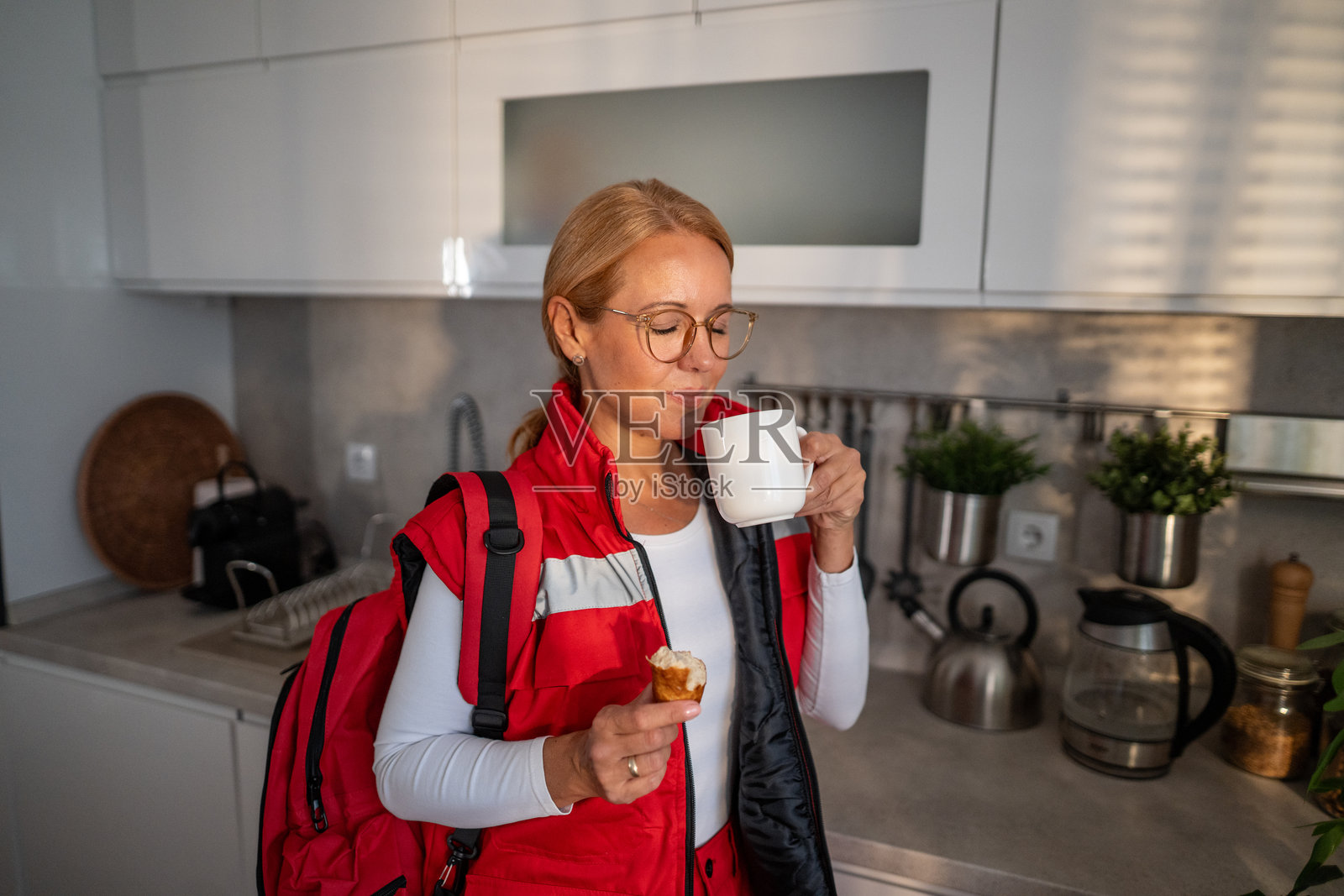 一名女急救员正在厨房享用咖啡和早餐照片摄影图片