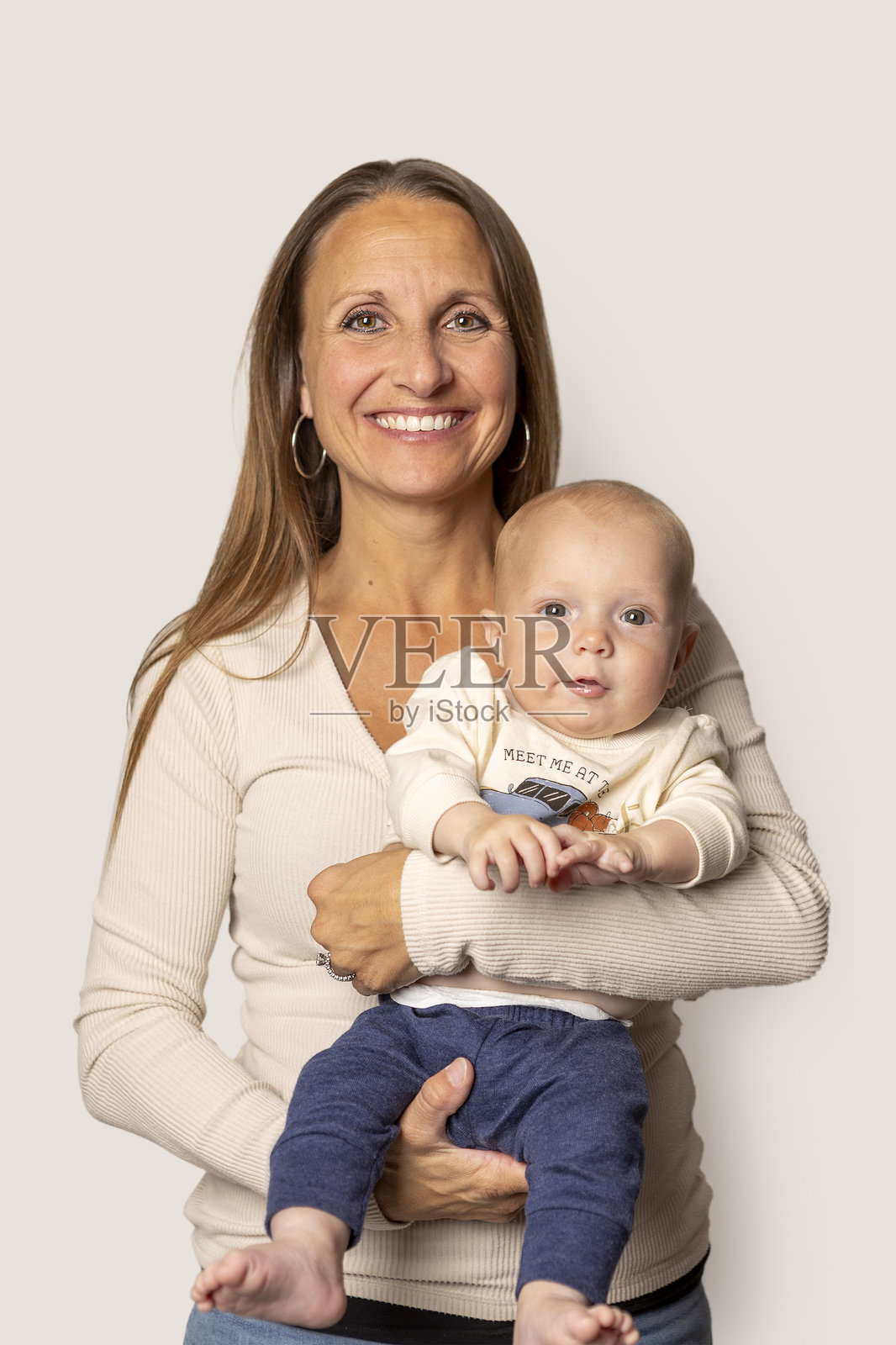 微笑着的母亲抱着她四个月大的儿子照片摄影图片