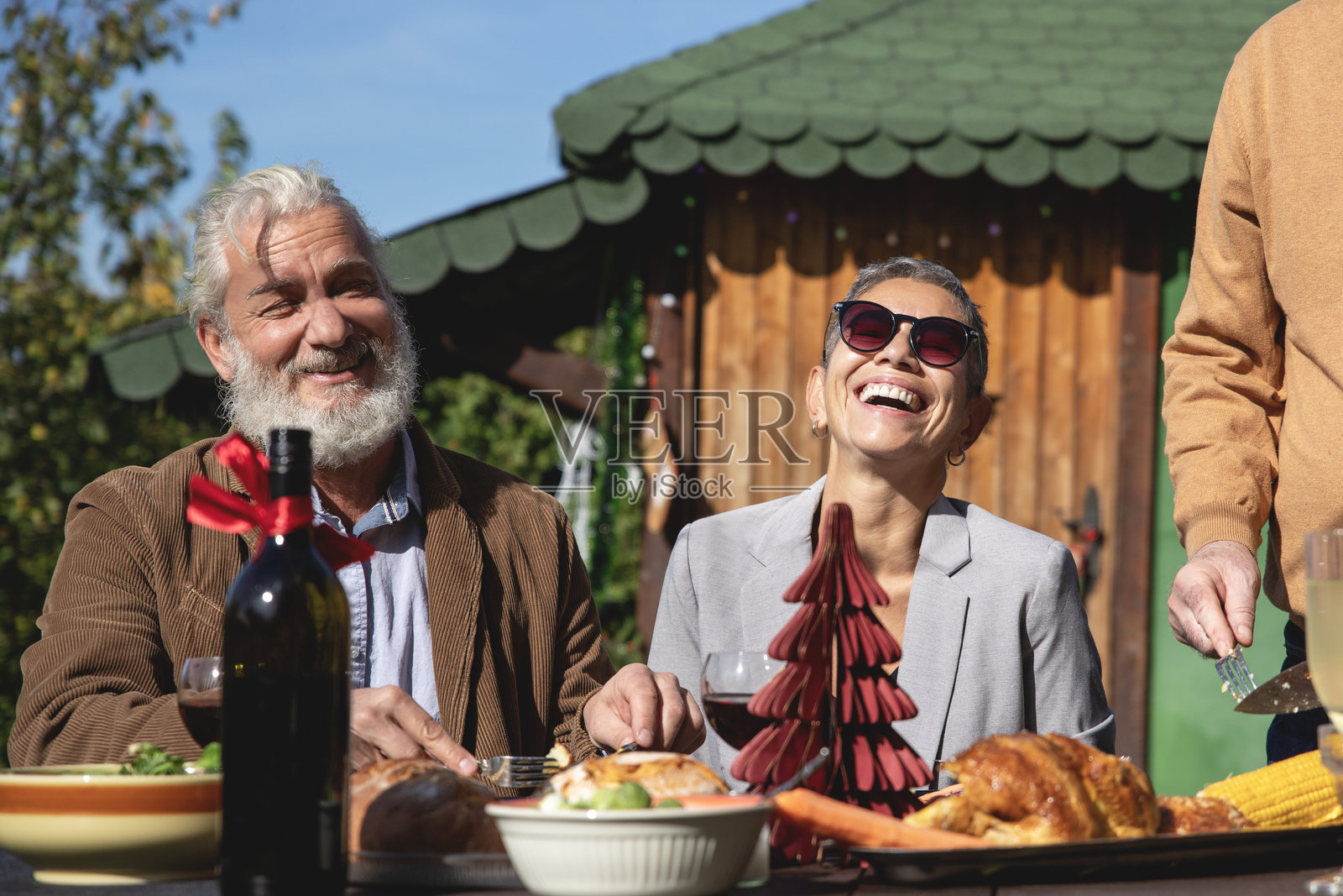 成熟的朋友们在花园里享用午餐照片摄影图片