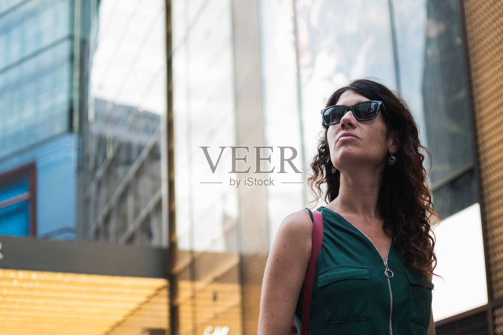 戴着太阳镜的女性正在探索城市街道照片摄影图片