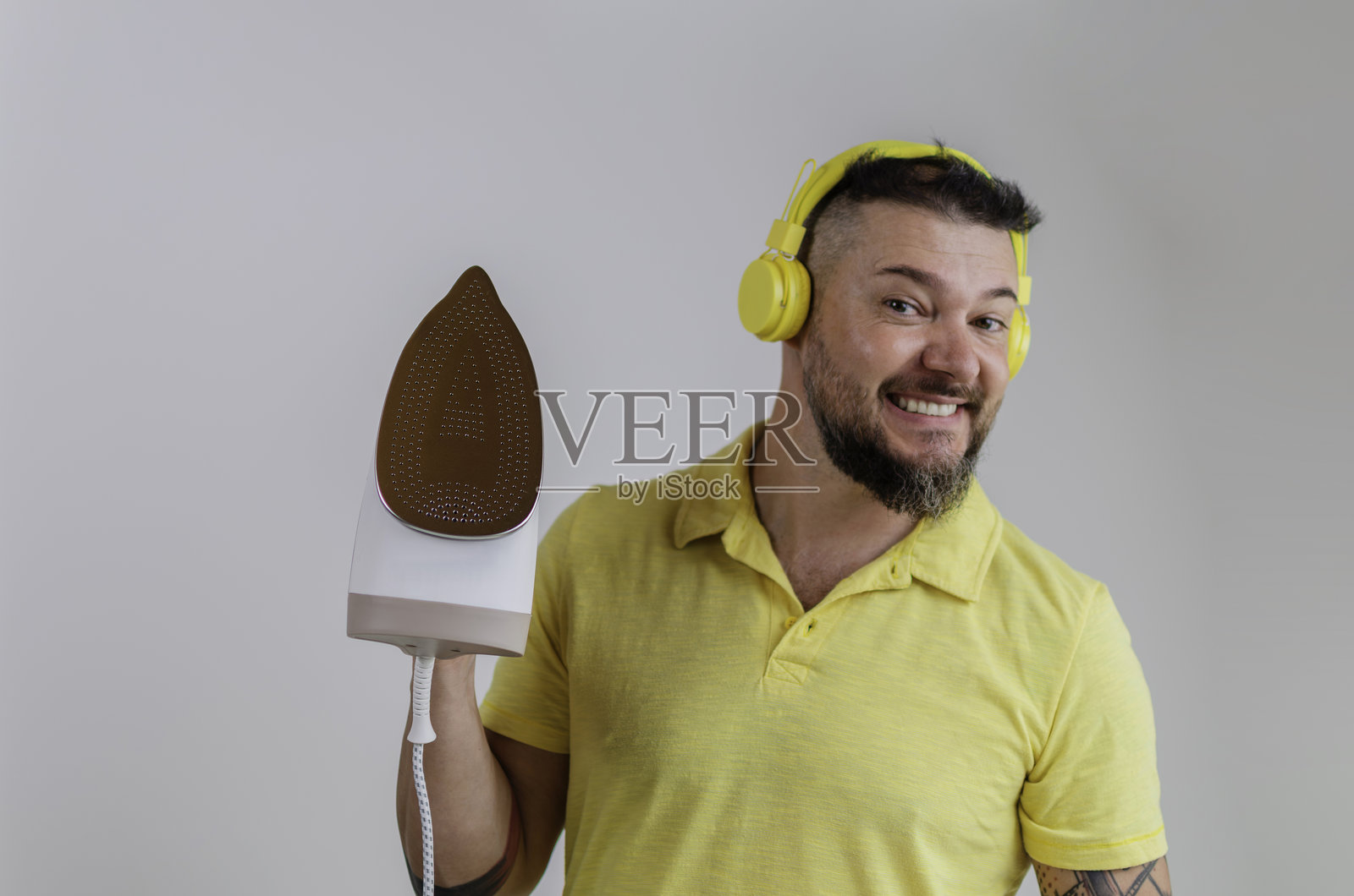 男人一边做家务一边听音乐，脸上带着笑容照片摄影图片