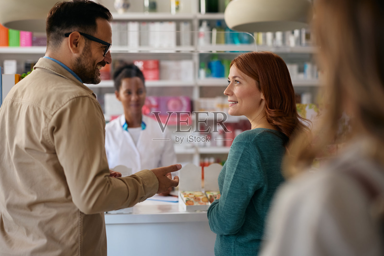 一对快乐的夫妇正在药店买药时交谈。照片摄影图片