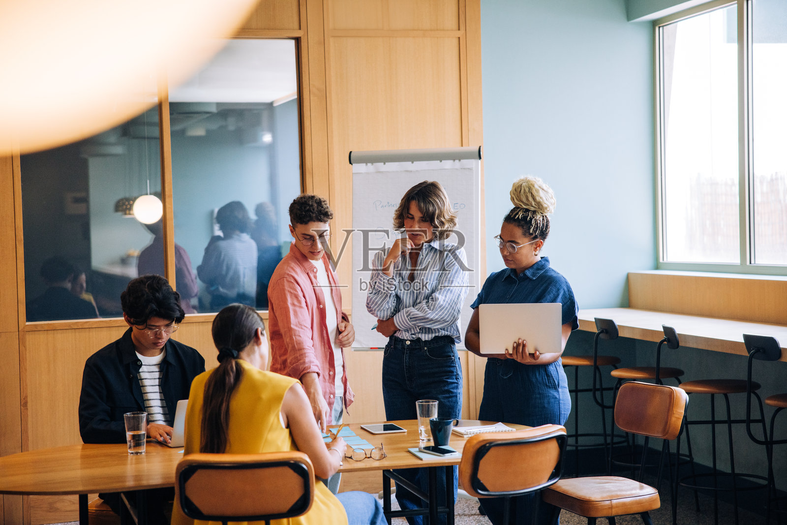 一群年轻的专业人士在办公室的桌子旁进行讨论照片摄影图片
