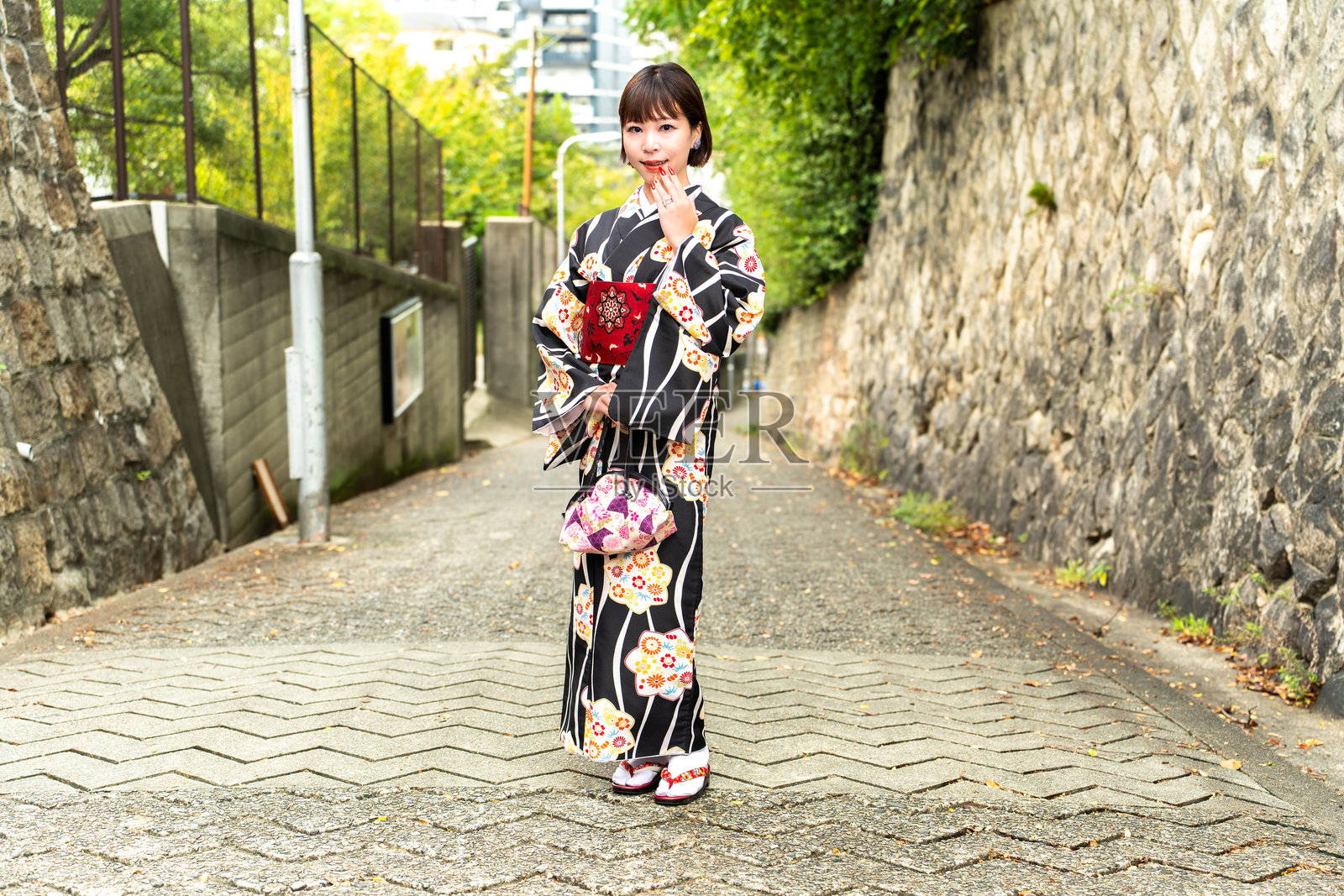 一位日本女性站在名为“爱染坂”的斜坡上照片摄影图片