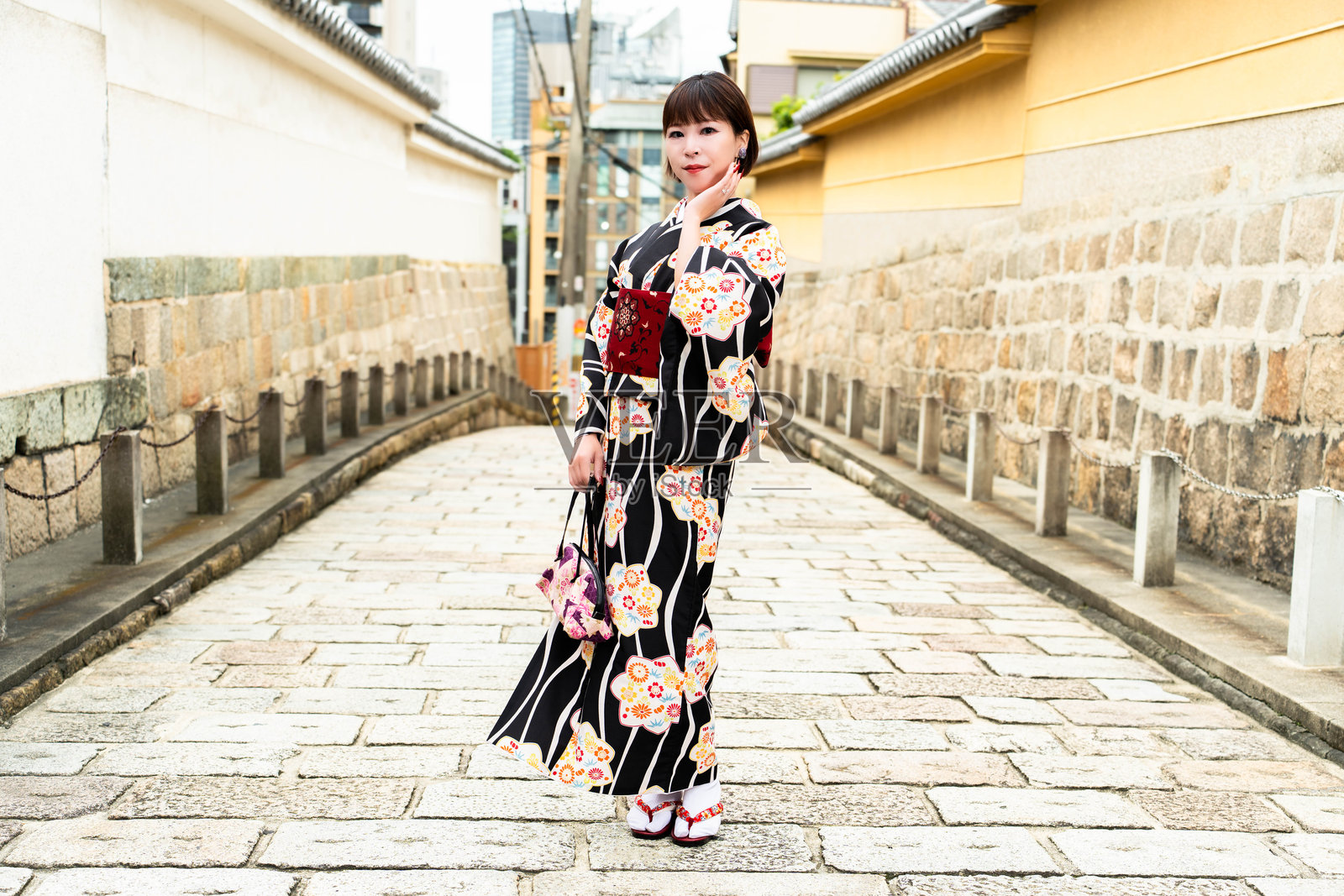 一位日本女性站在名为“玄照寺坂”的斜坡上照片摄影图片