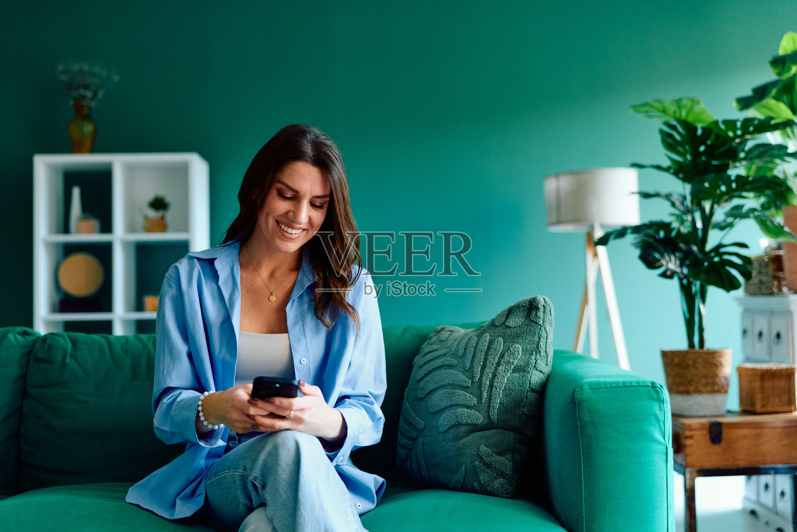 年轻女子在家放松地使用智能手机照片摄影图片