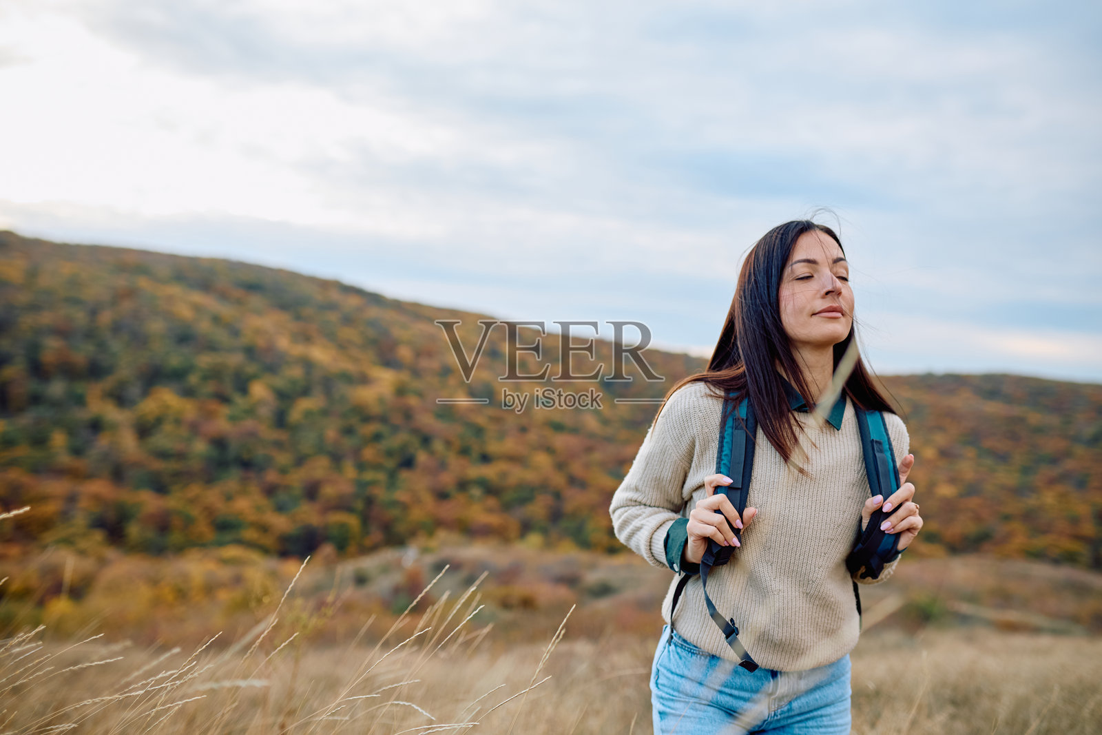 一位女士在秋季的户外徒步，感受清新的空气照片摄影图片